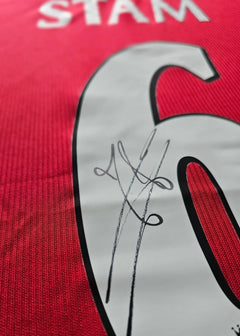 Detail showing the signature on the No. 6 red Manchester United football shirt.