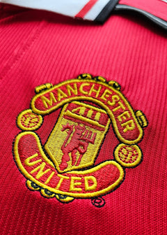 Close-up of Manchester United crest featuring red and yellow details.