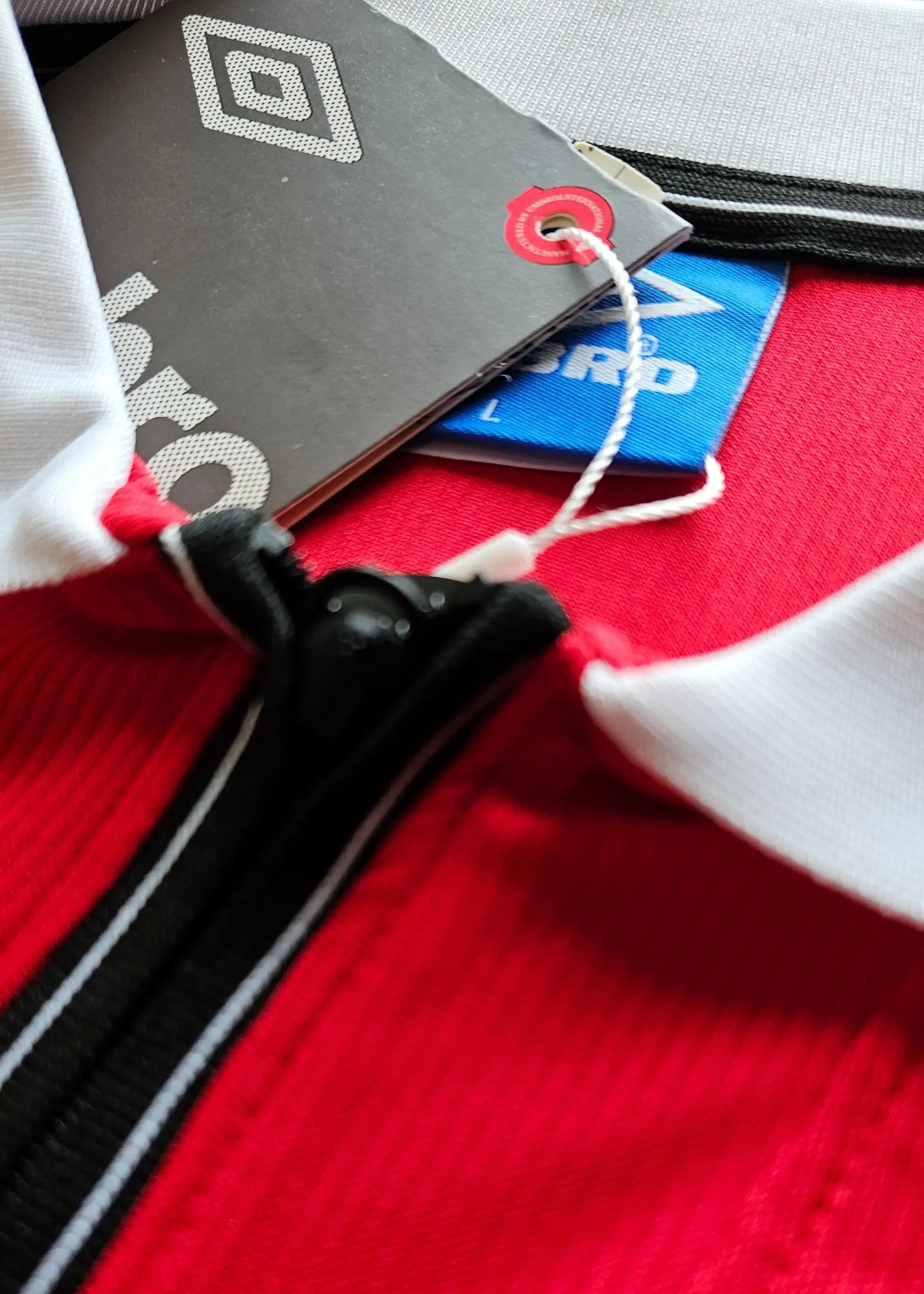 Close-up detail showing the collar and tags of a Jaap Stam signed Manchester United football shirt.