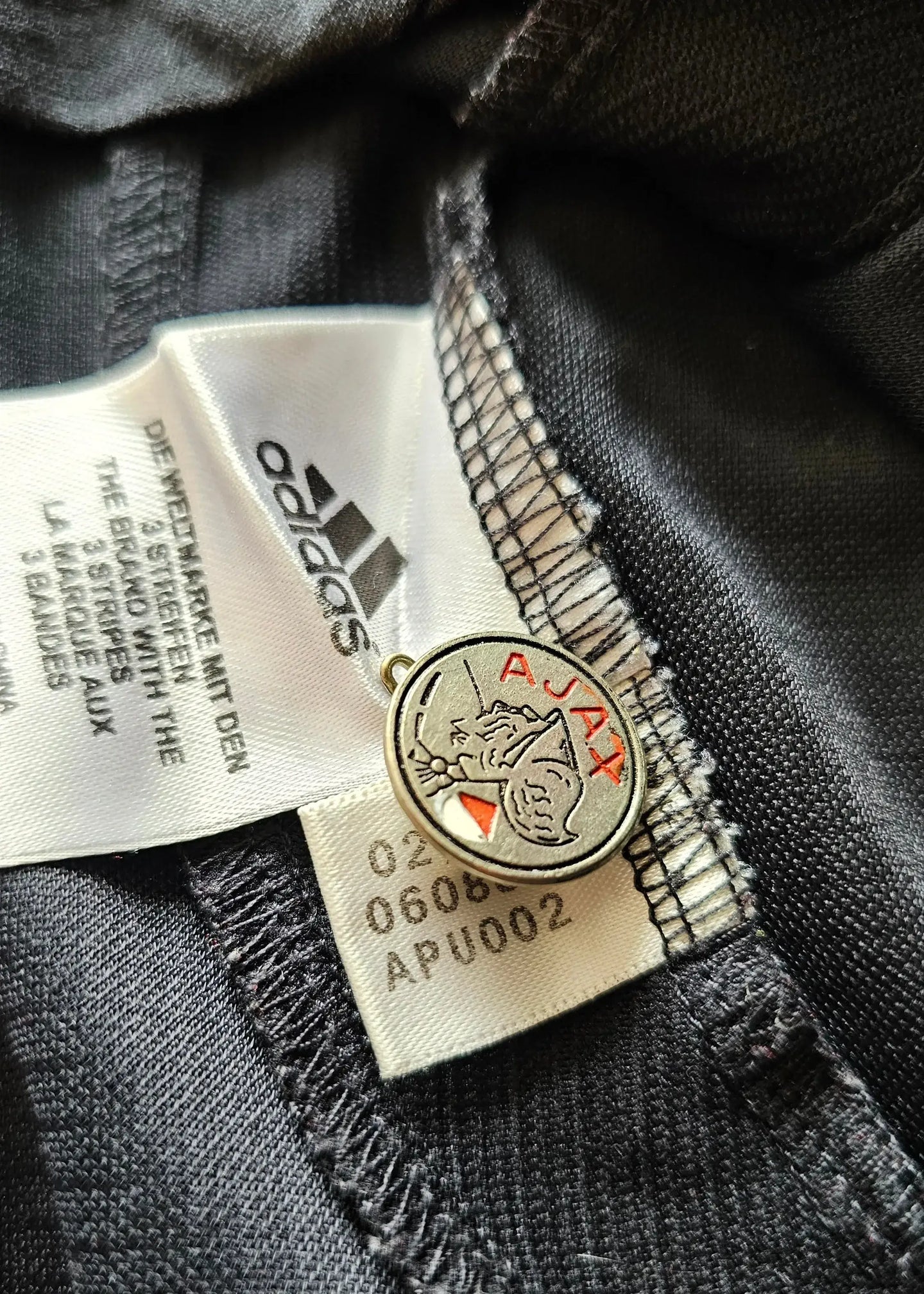 Detail showing AFC Ajax crest and adidas tag on Jaap Stam signed football shirt.