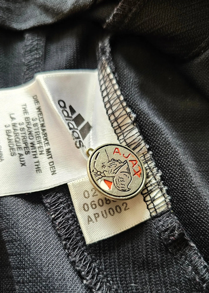 Detail showing AFC Ajax crest and adidas tag on Jaap Stam signed football shirt.