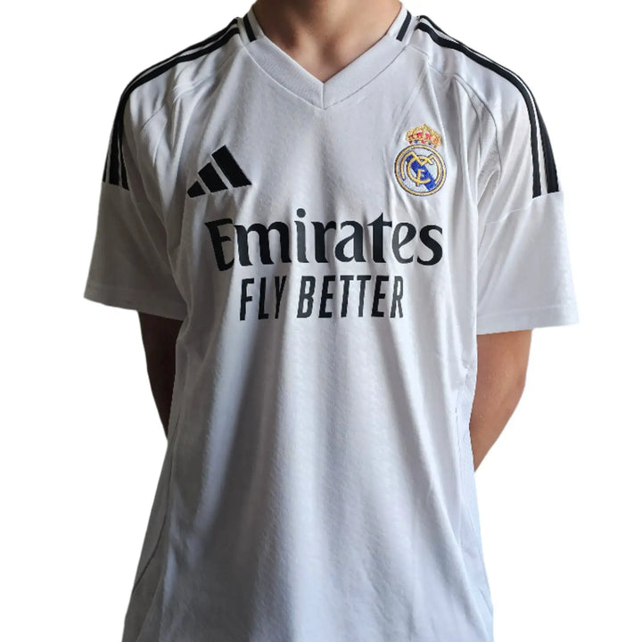 Front view of a Real Madrid 2024-25 football shirt featuring adidas and Emirates logos.