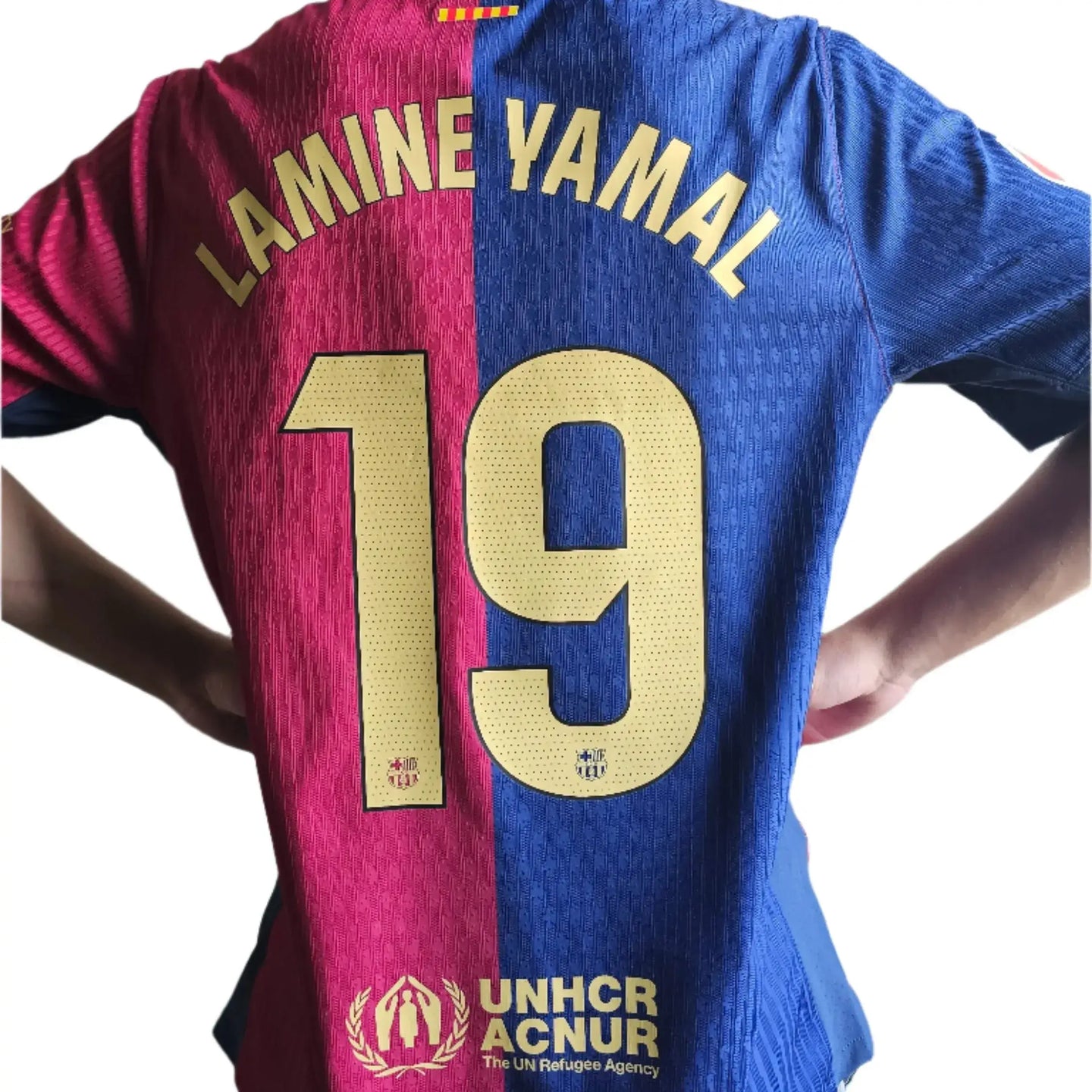 Back view showing Lamine Yamal, No. 19 and Barcelona crest with UNHCR logo.