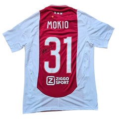 Back view showing signature, name Mokio, and No. 31 on a red and white Ajax football shirt.