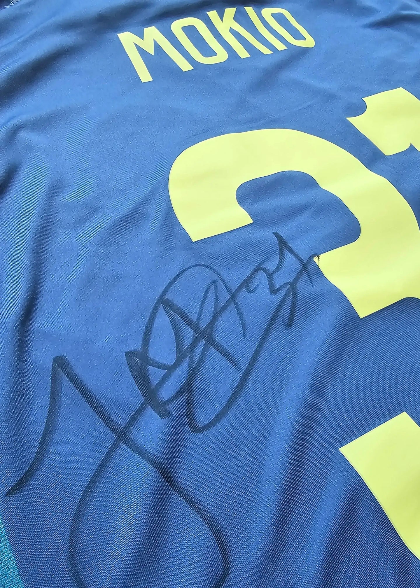 Back view featuring Mokio, No. 31, with a visible signature in black ink.