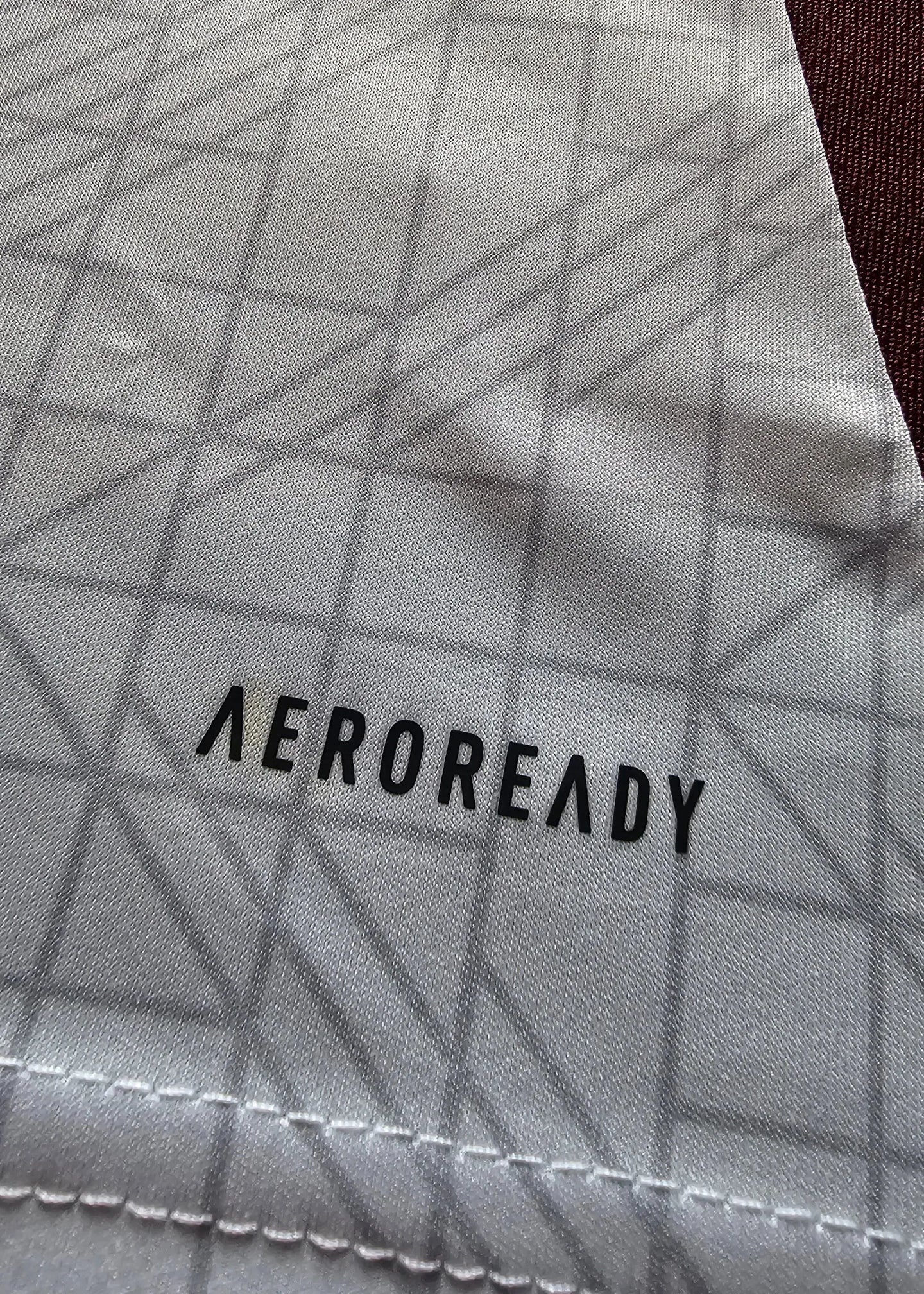 Close-up of AEROREADY branding on fabric with geometric pattern.