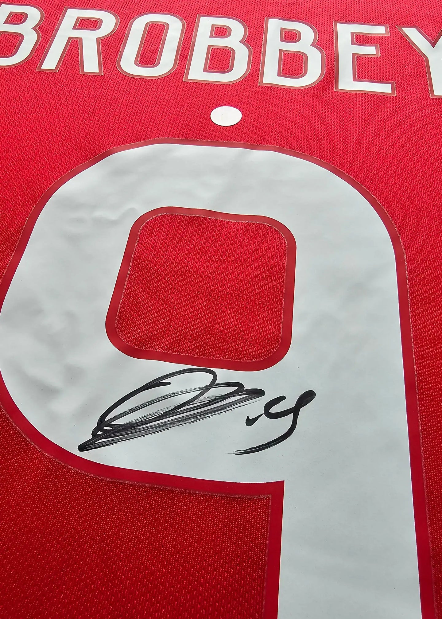 Detail view showing the number 9 and Brian Brobbey's signature on a red football shirt.