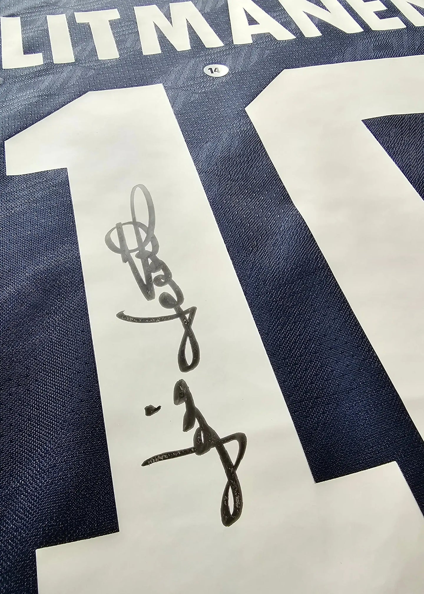 Signature detail of Jari Litmanen on No. 10, navy blue football shirt.