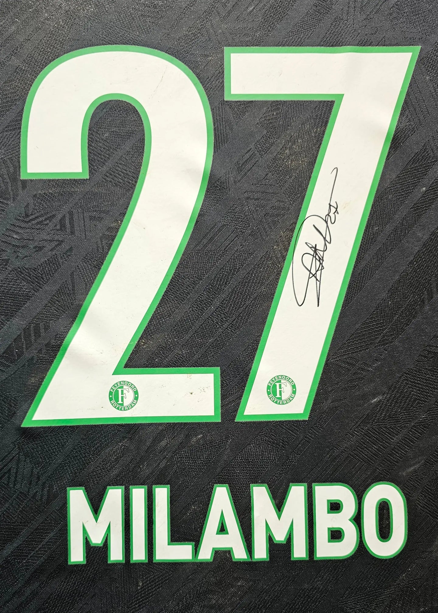 Close-up of the No. 27 with signature and Feyenoord badge on football shirt.