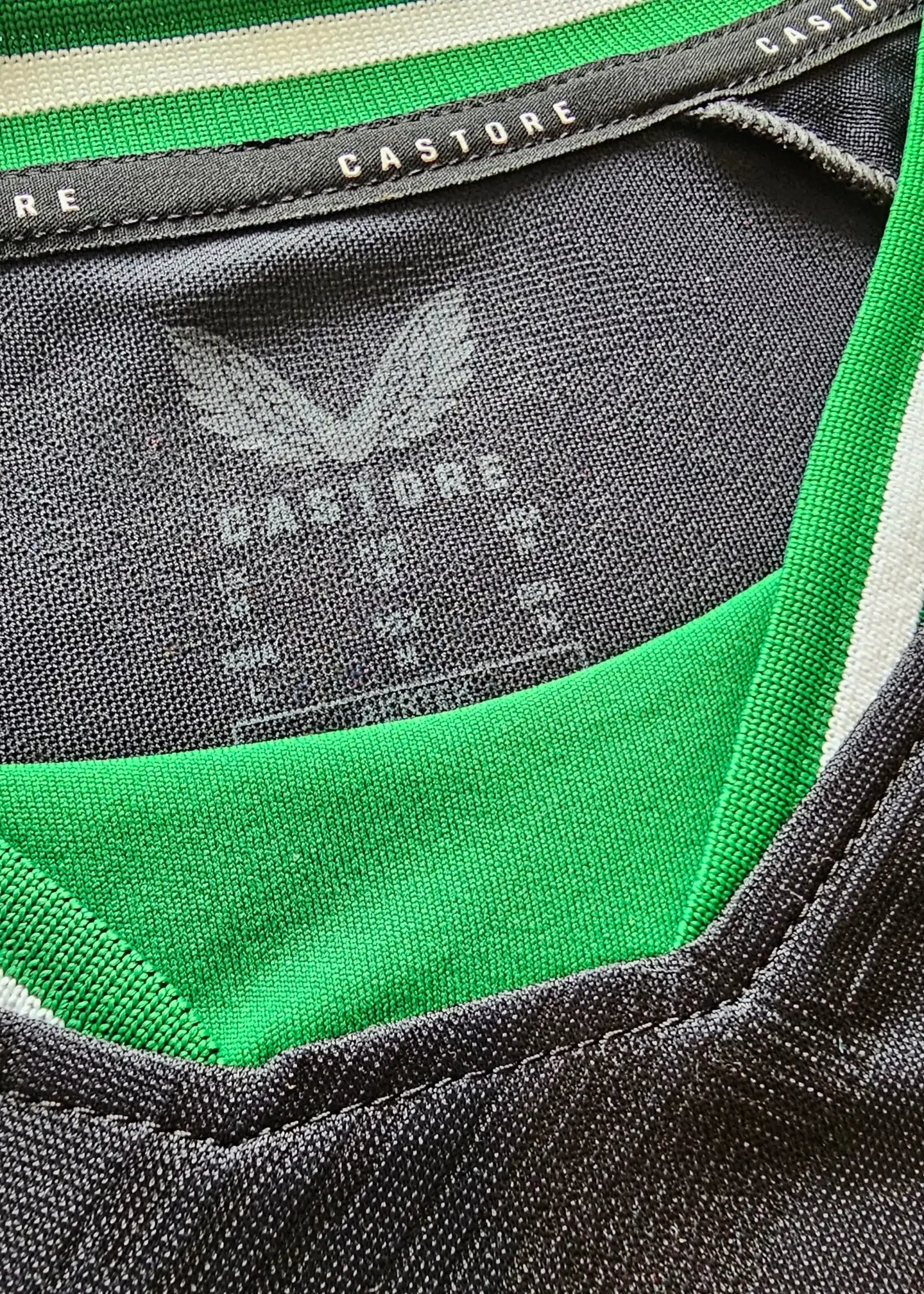 Detail view showing the Castore label and neckline of the football shirt.