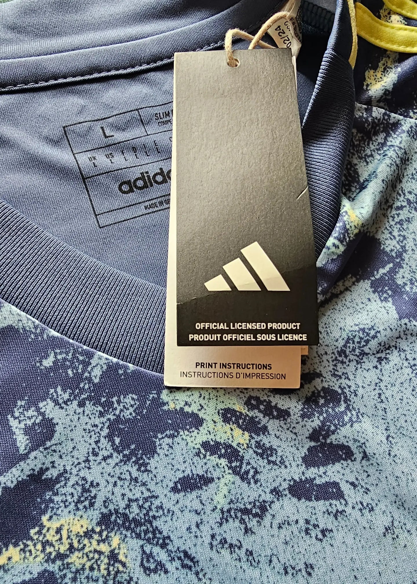 Label detail showing size L and adidas branding with care instructions attached.
