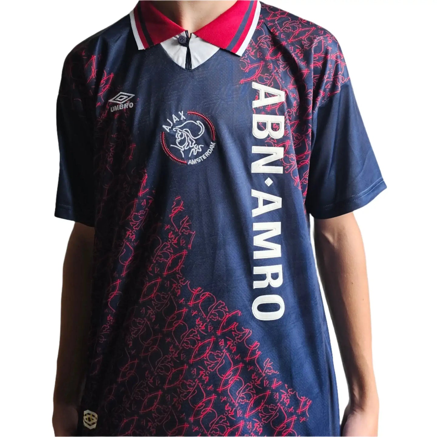 Back view showing ABN AMRO sponsor, AJAX crest, and player details in navy and red design.