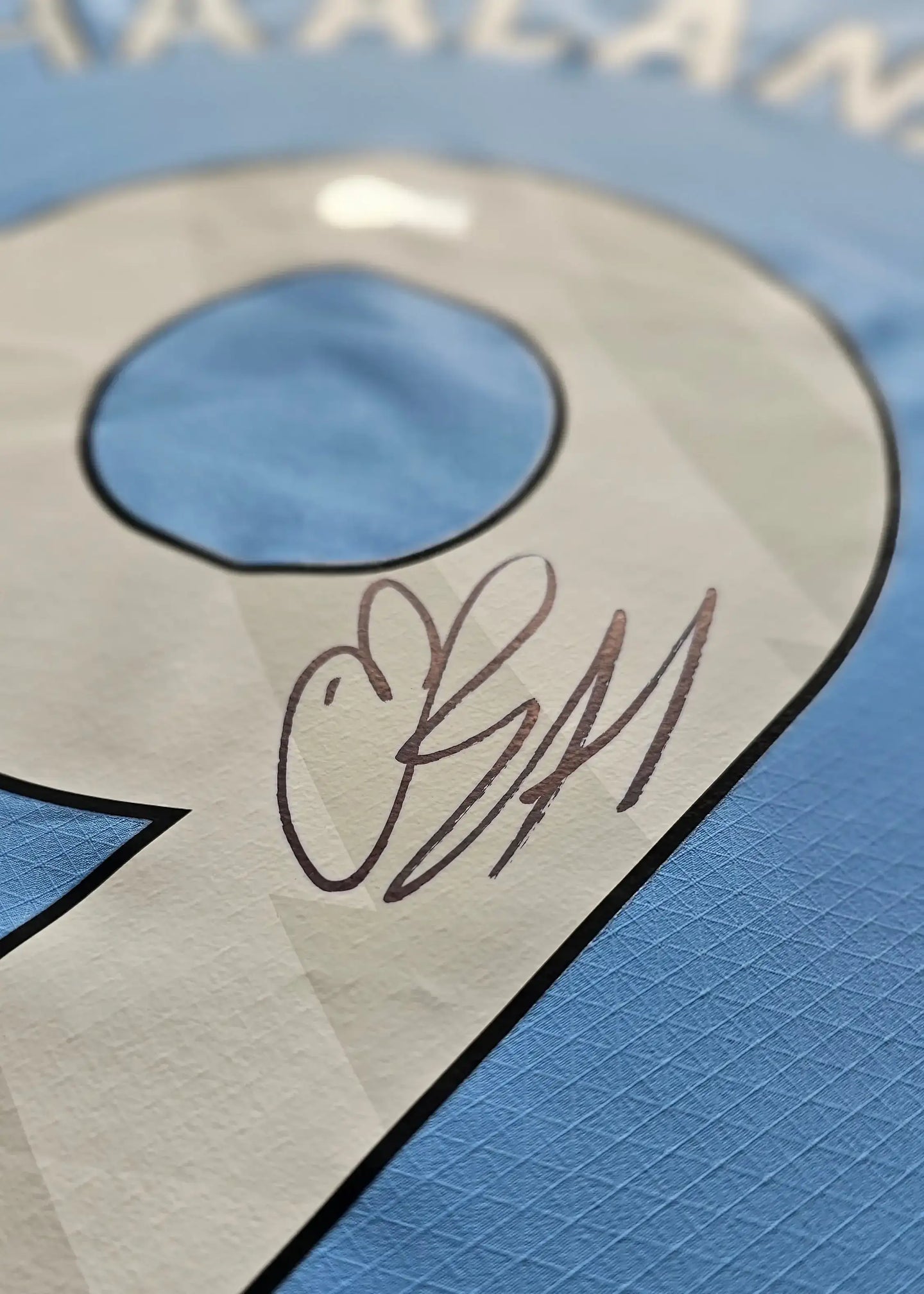 Close-up of No. 9 with Erling Haaland's signature on a Manchester City football shirt.