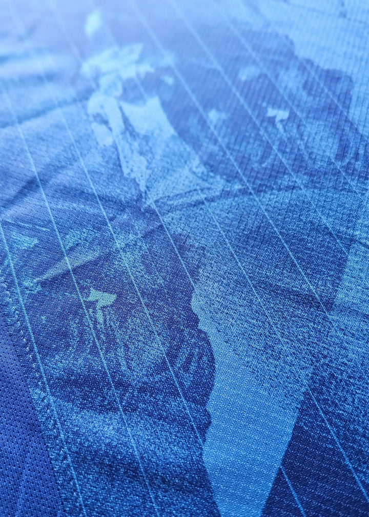 Close-up of textured blue football shirt featuring Liam Delap&