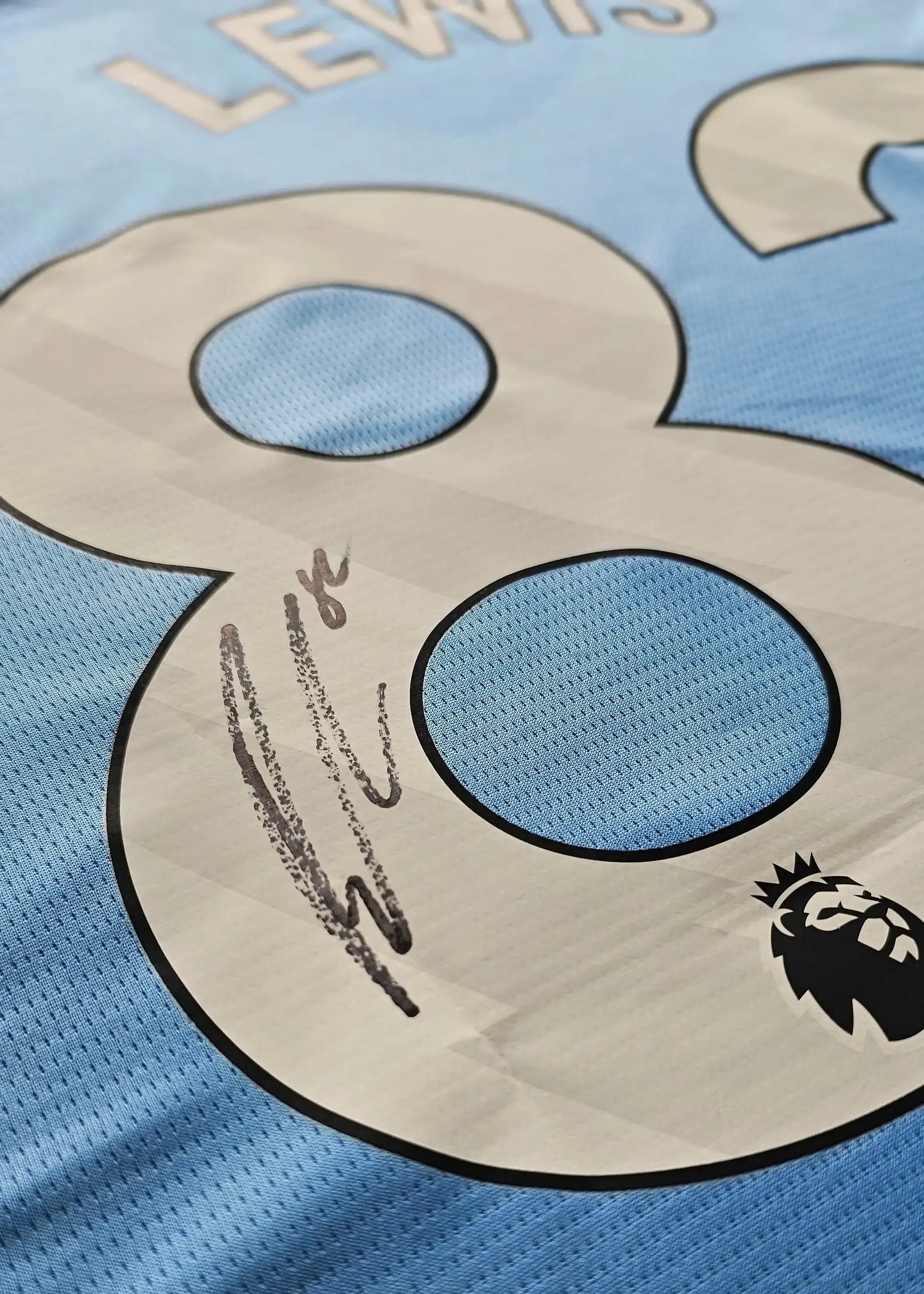 Close-up of No. 82 with signature detail and Premier League logo on the football shirt.
