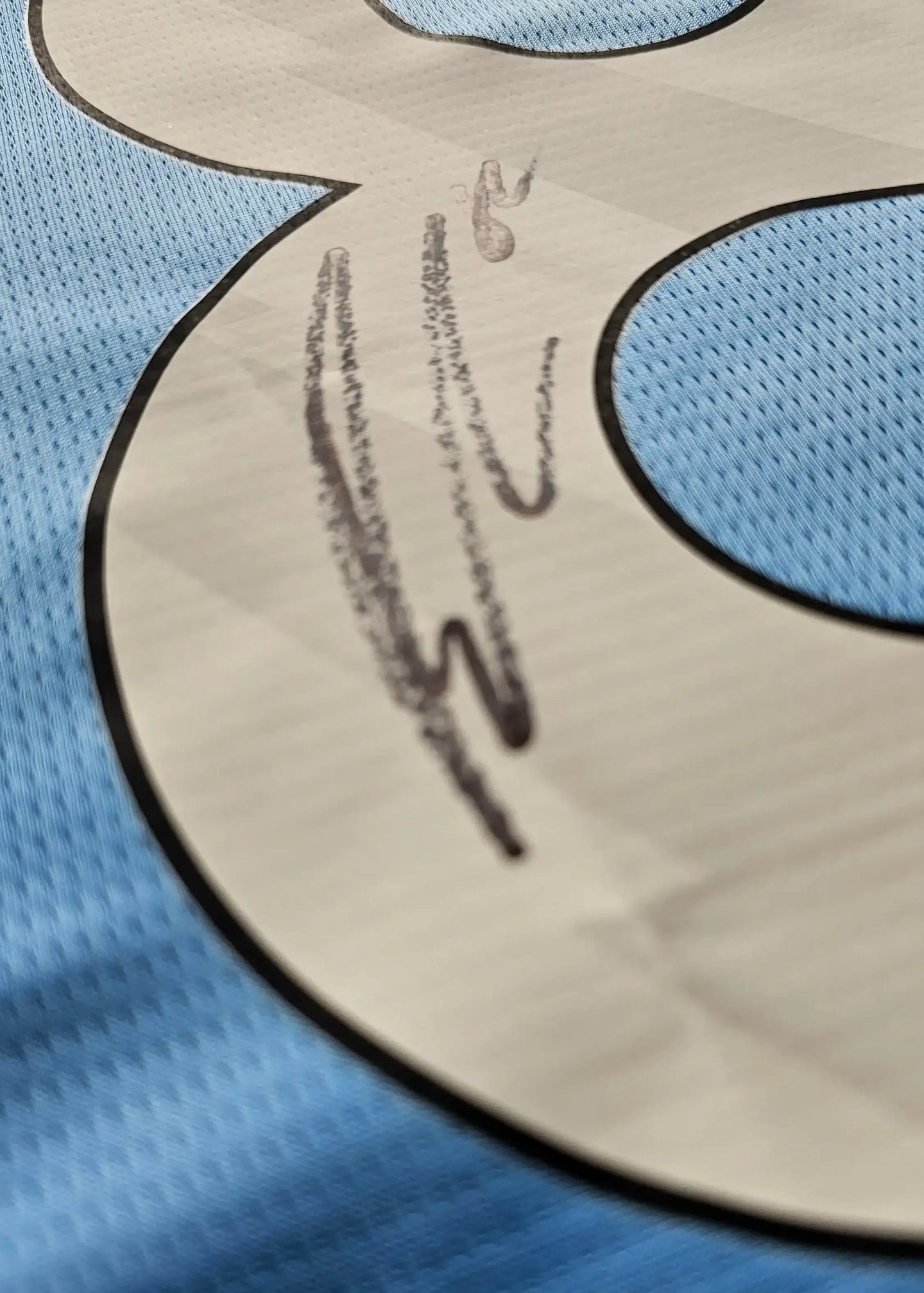 Close-up of signature detail on No. 82 blue Manchester City football shirt.