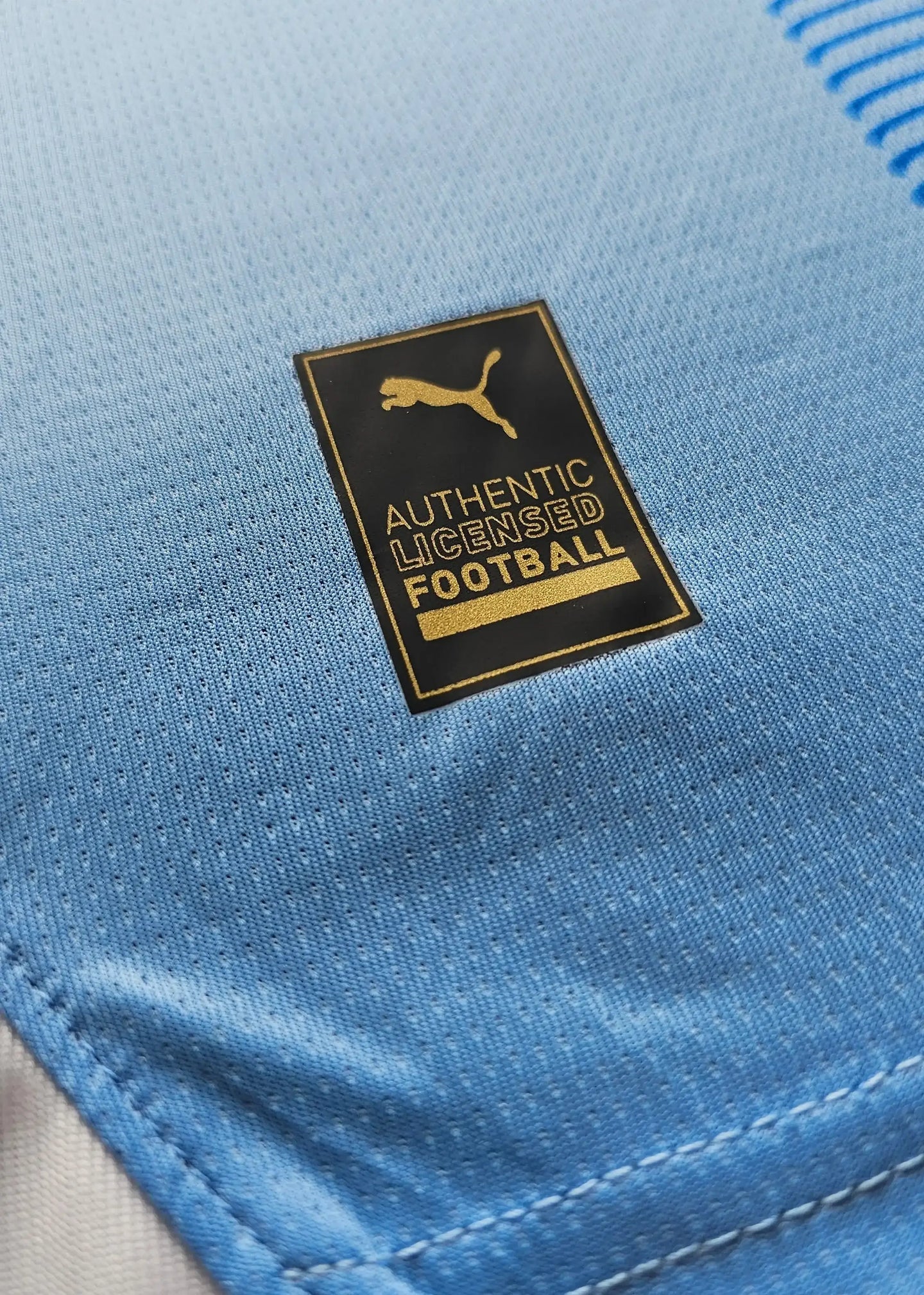 Detail view showing the 'AUTHENTIC LICENSED FOOTBALL' tag and Puma logo on the football shirt.