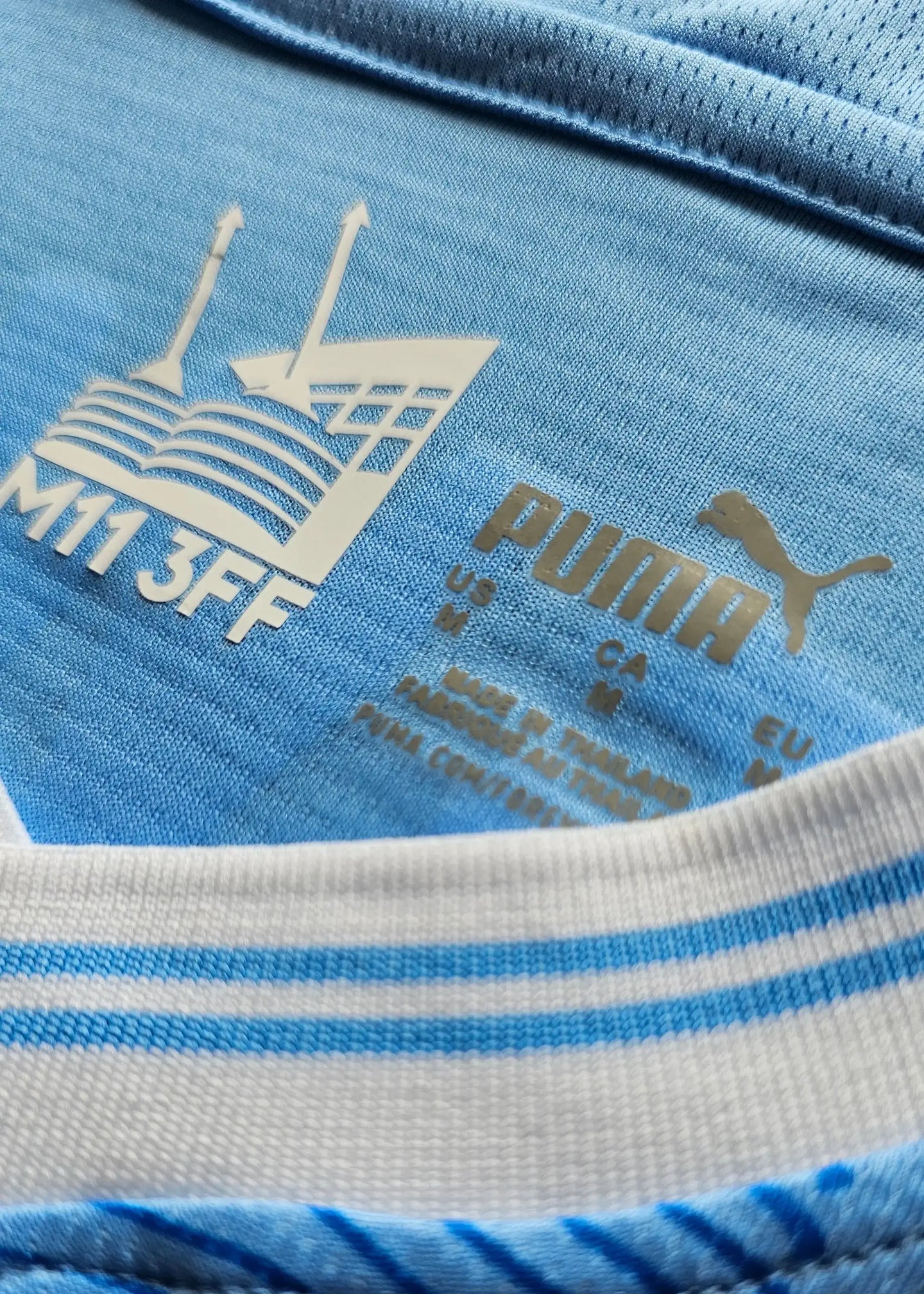 Detail view showing PUMA brand mark and blue design features on the collar.