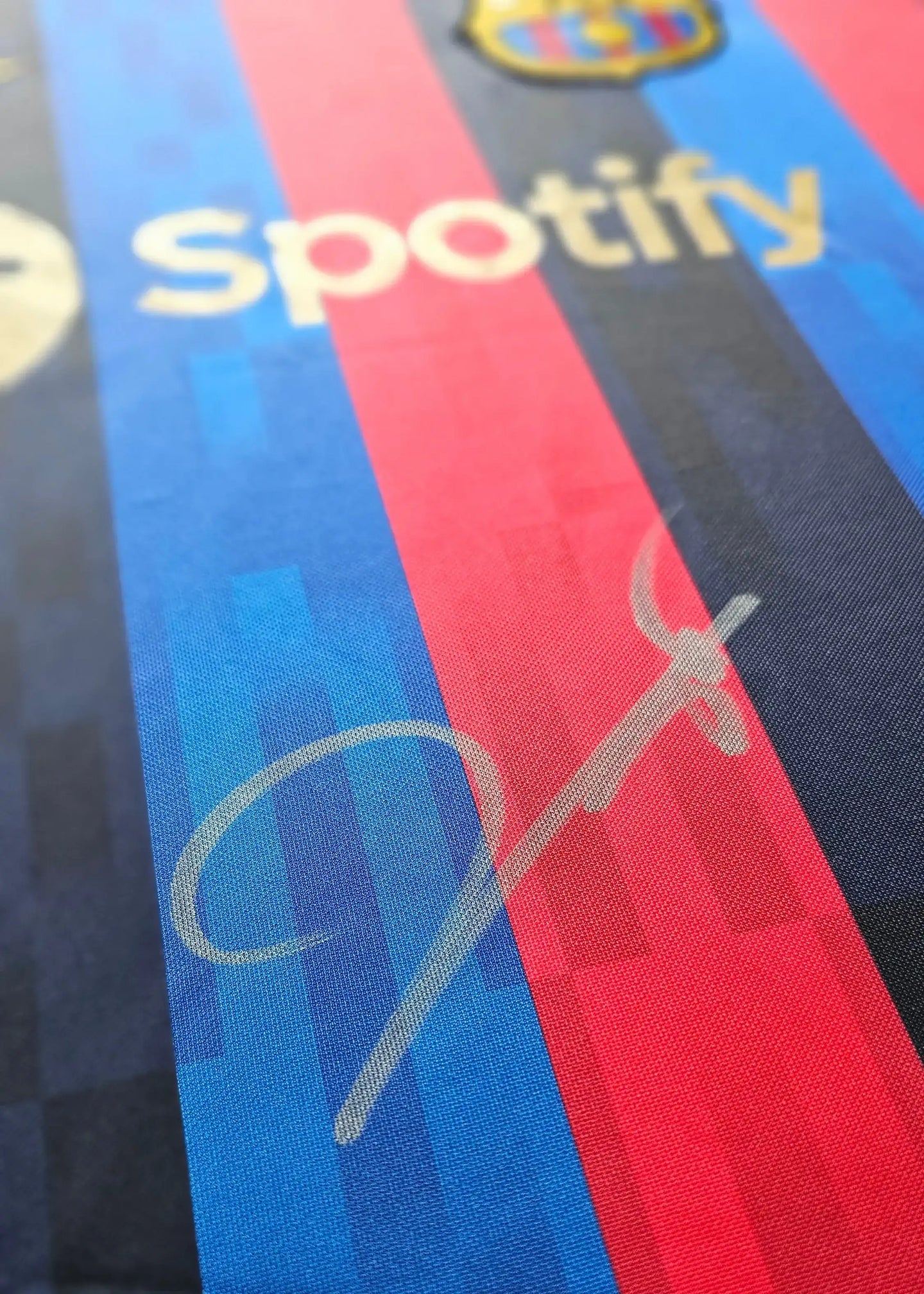 Close-up of signature on blue and red Barcelona football shirt featuring Spotify branding.