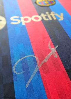 Close-up of signature on blue and red Barcelona football shirt featuring Spotify branding.