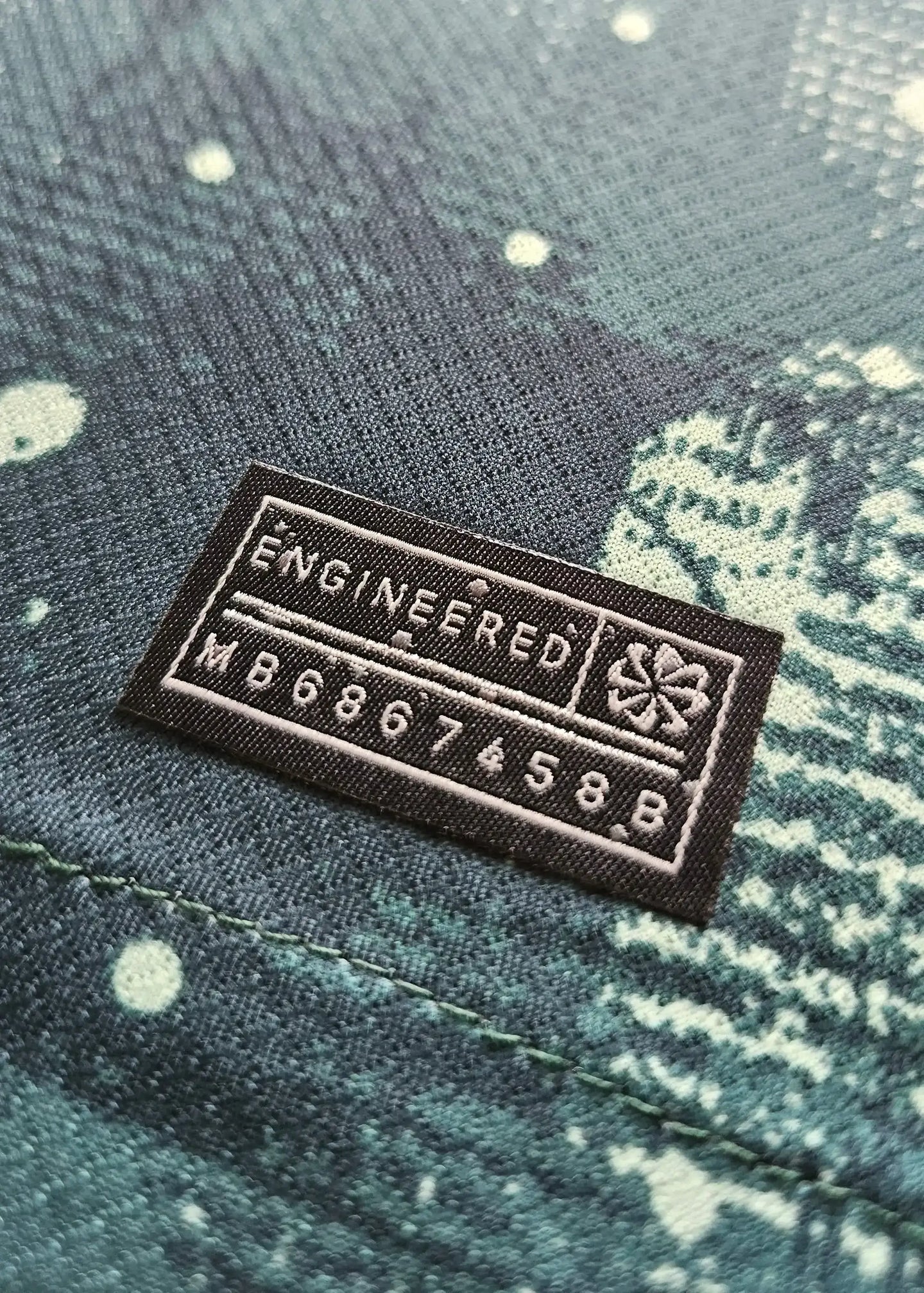 Close-up view of the 'ENGINEERED' label and care details on Wilson Odobert's signed football shirt.