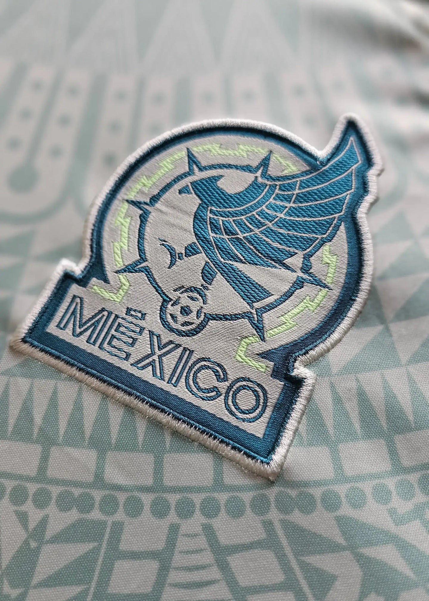 Close-up of Mexico crest featuring the word 'MÉXICO' and a soccer ball design.