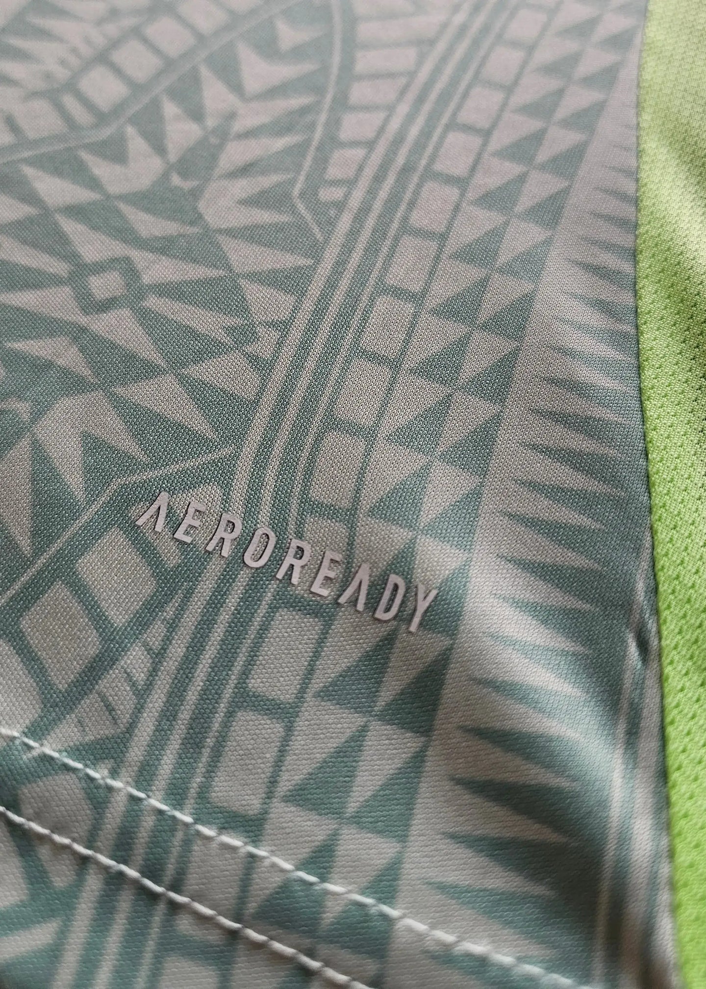 Close-up showing AEROREADY text on the fabric with green and patterned detail.