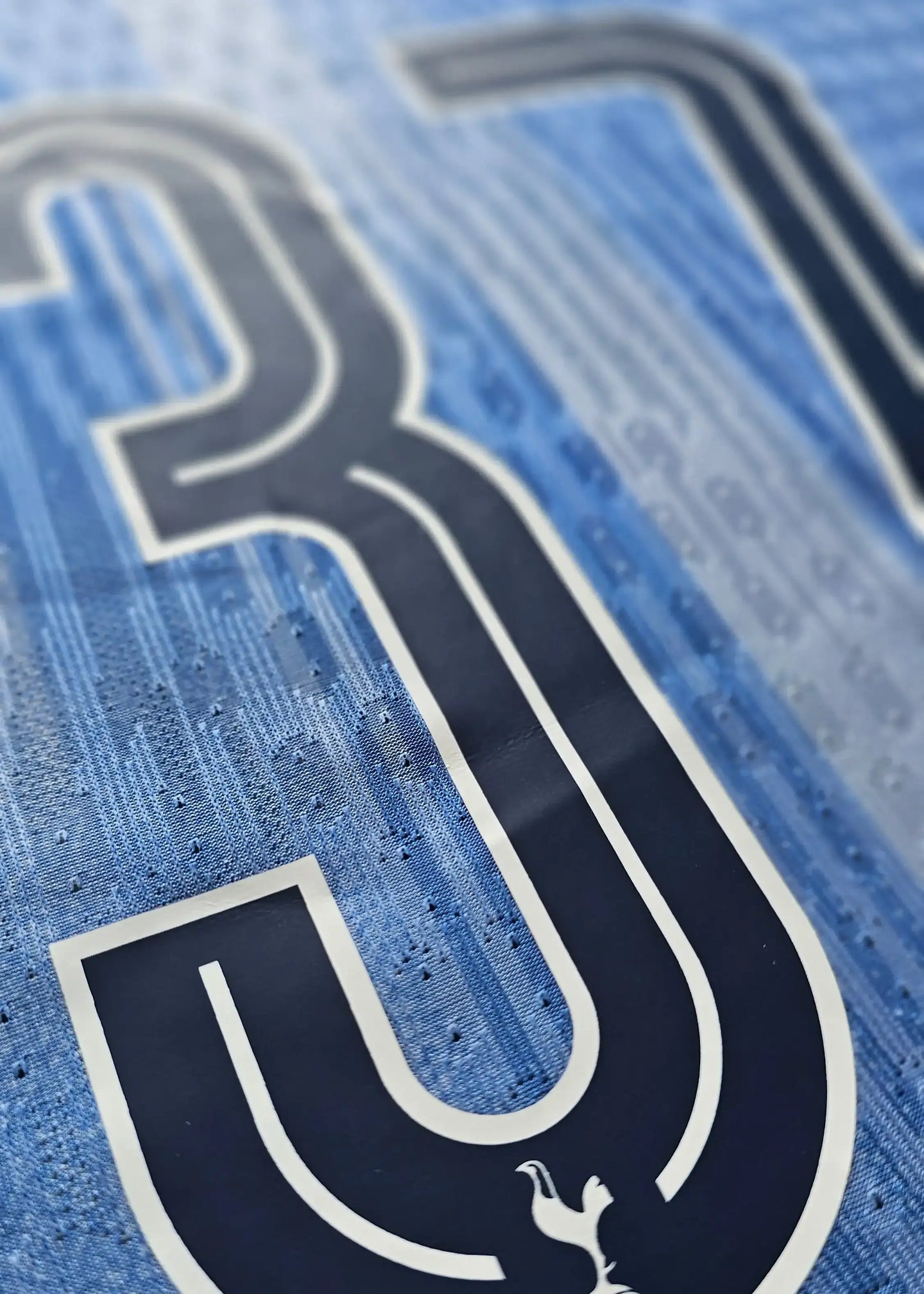 Close-up of No. 37 with signature detail on a blue Tottenham football shirt.