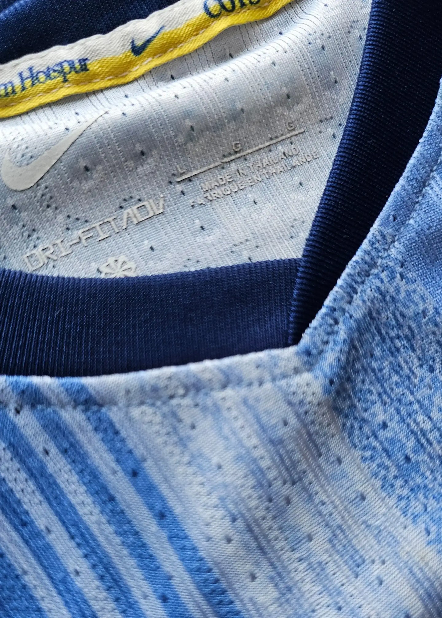 Close-up view of the collar with Nike branding and DRI-FIT label in blue tones.