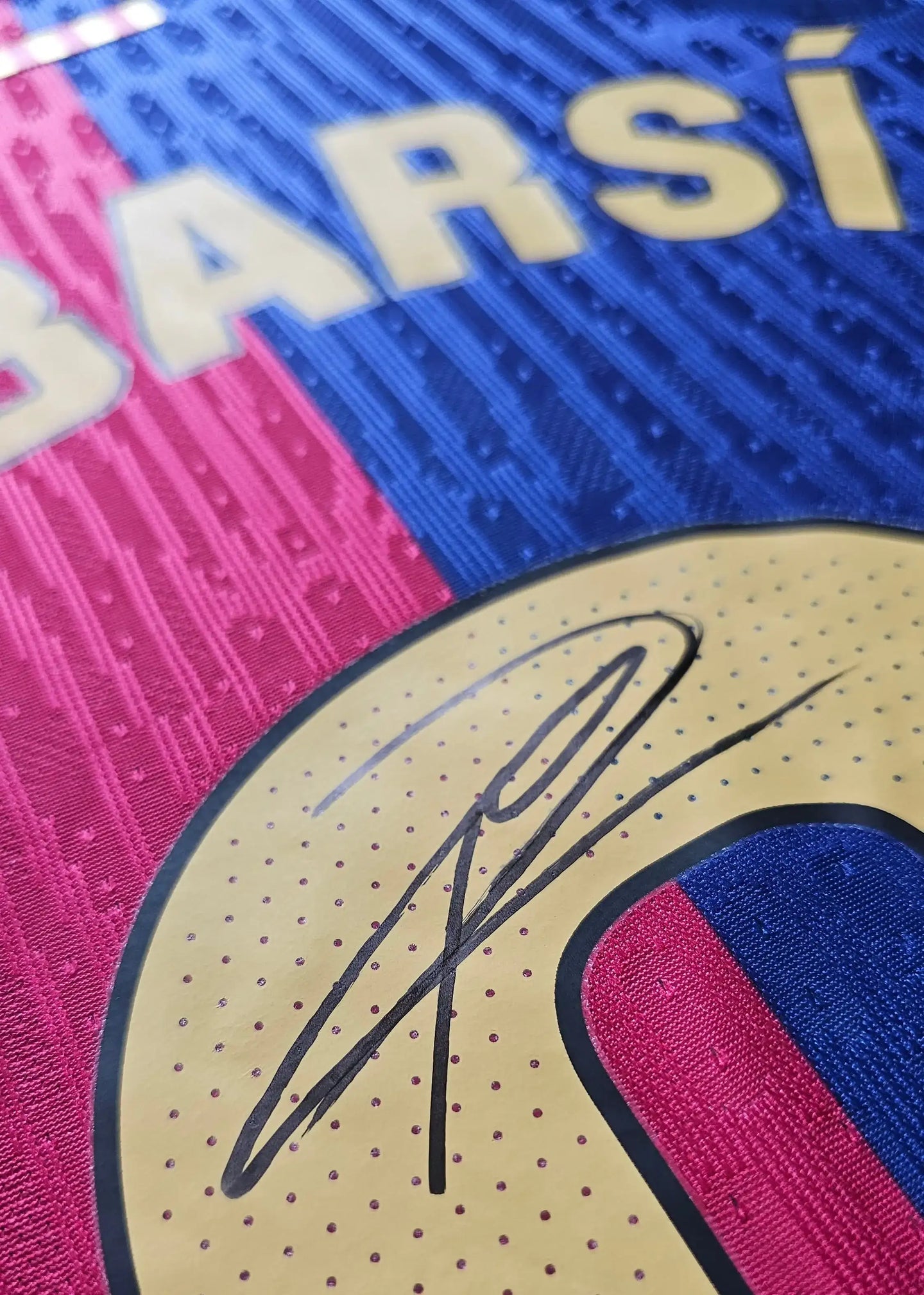 Close-up of the signature on the Pau Cubarsi signed Barcelona football shirt with blue and pink stripes.