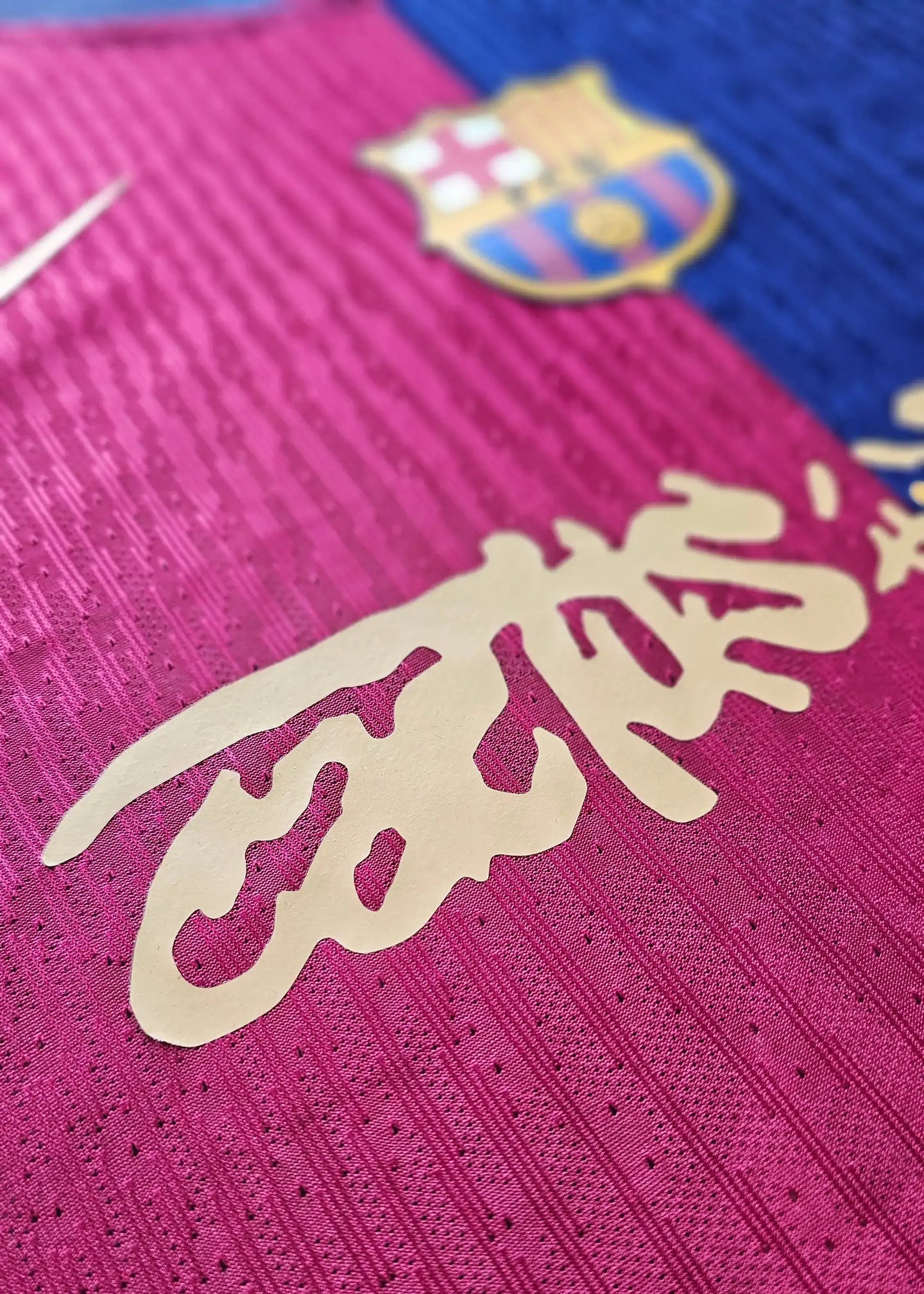 Close-up of the signature detail on a Barcelona football shirt, featuring the club crest.