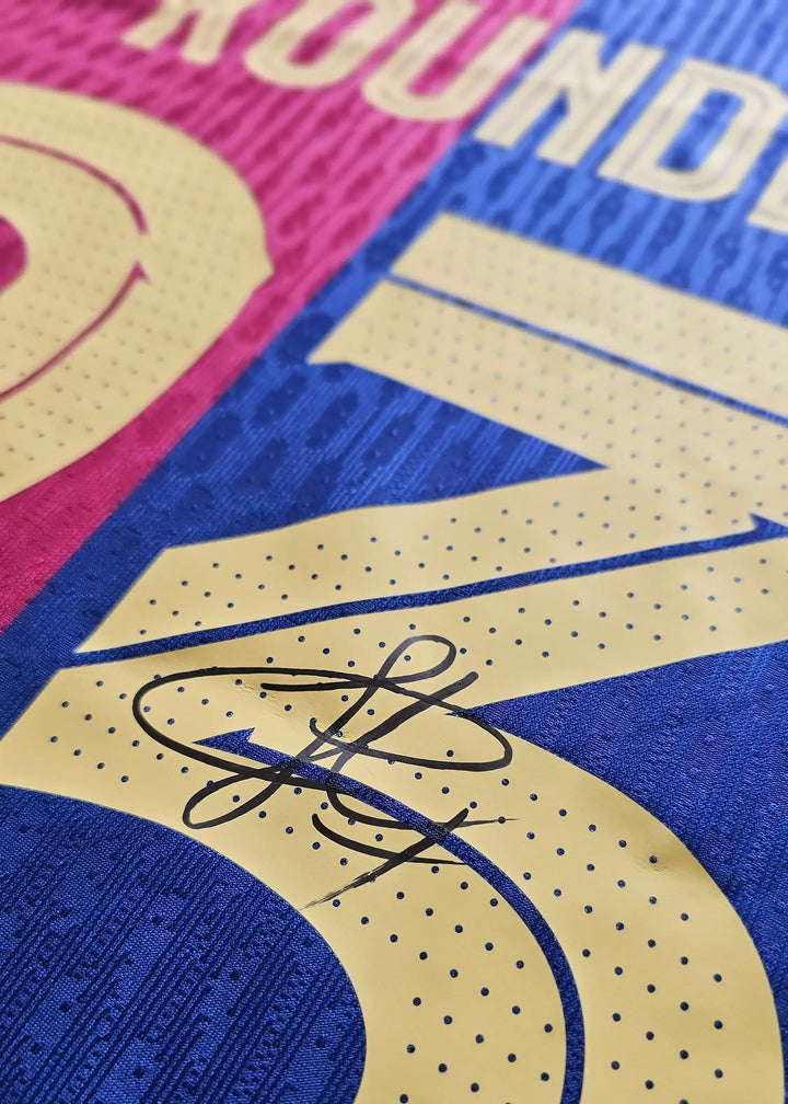 Close-up of signature on Jules Koundé No. 23 Barcelona football shirt in blue and red.