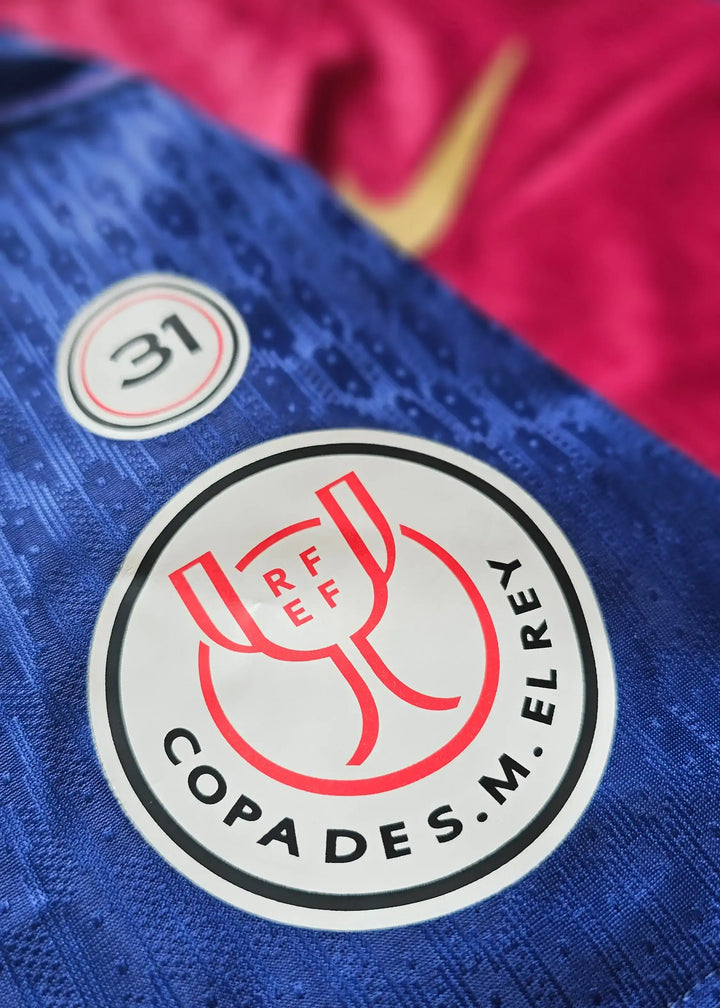 Crest detail with RFEF logo and 'COPA DES M. EL REY' on a blue background with No. 23.