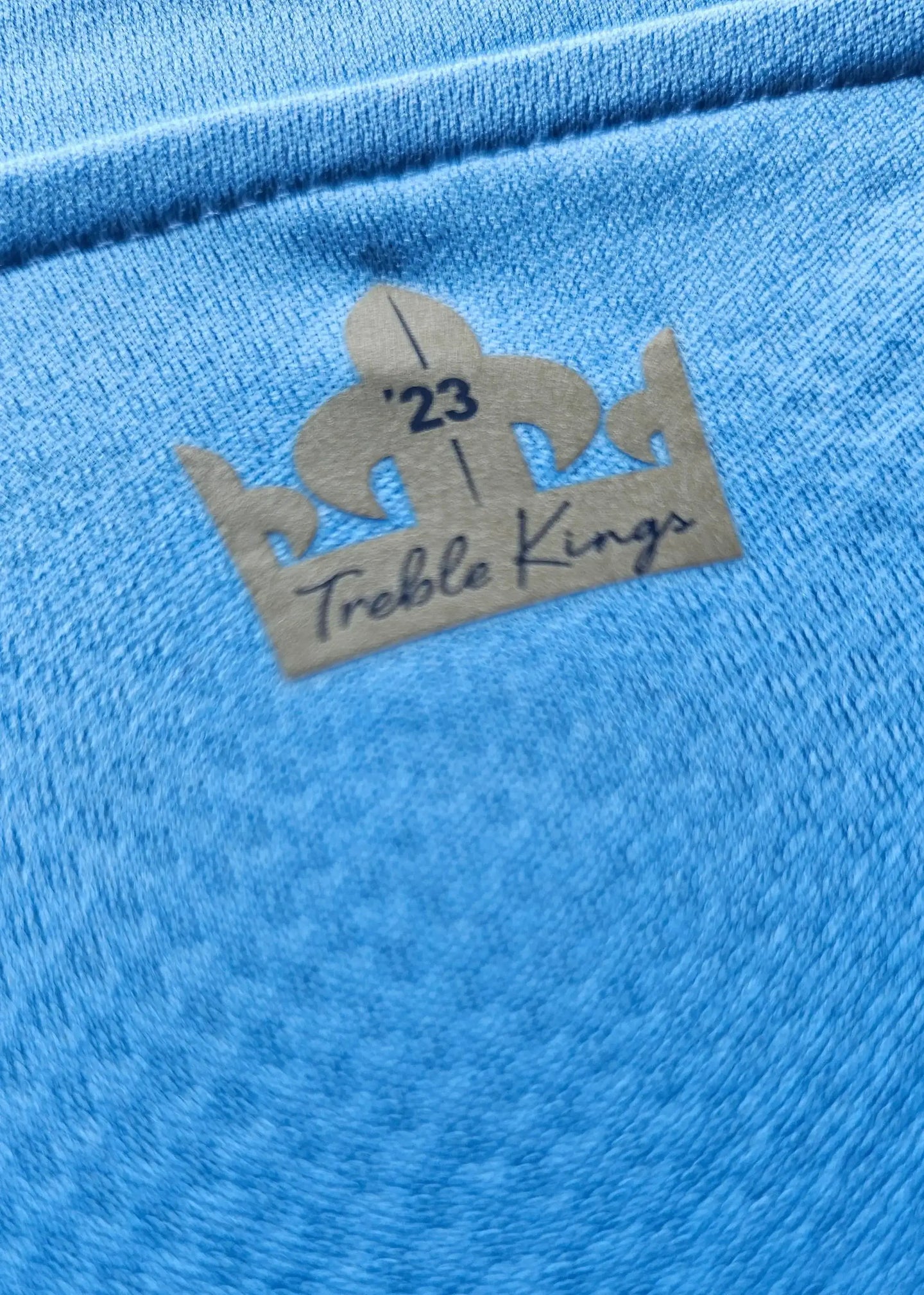 Detail showing the '23 Treble Kings' tag on blue fabric.