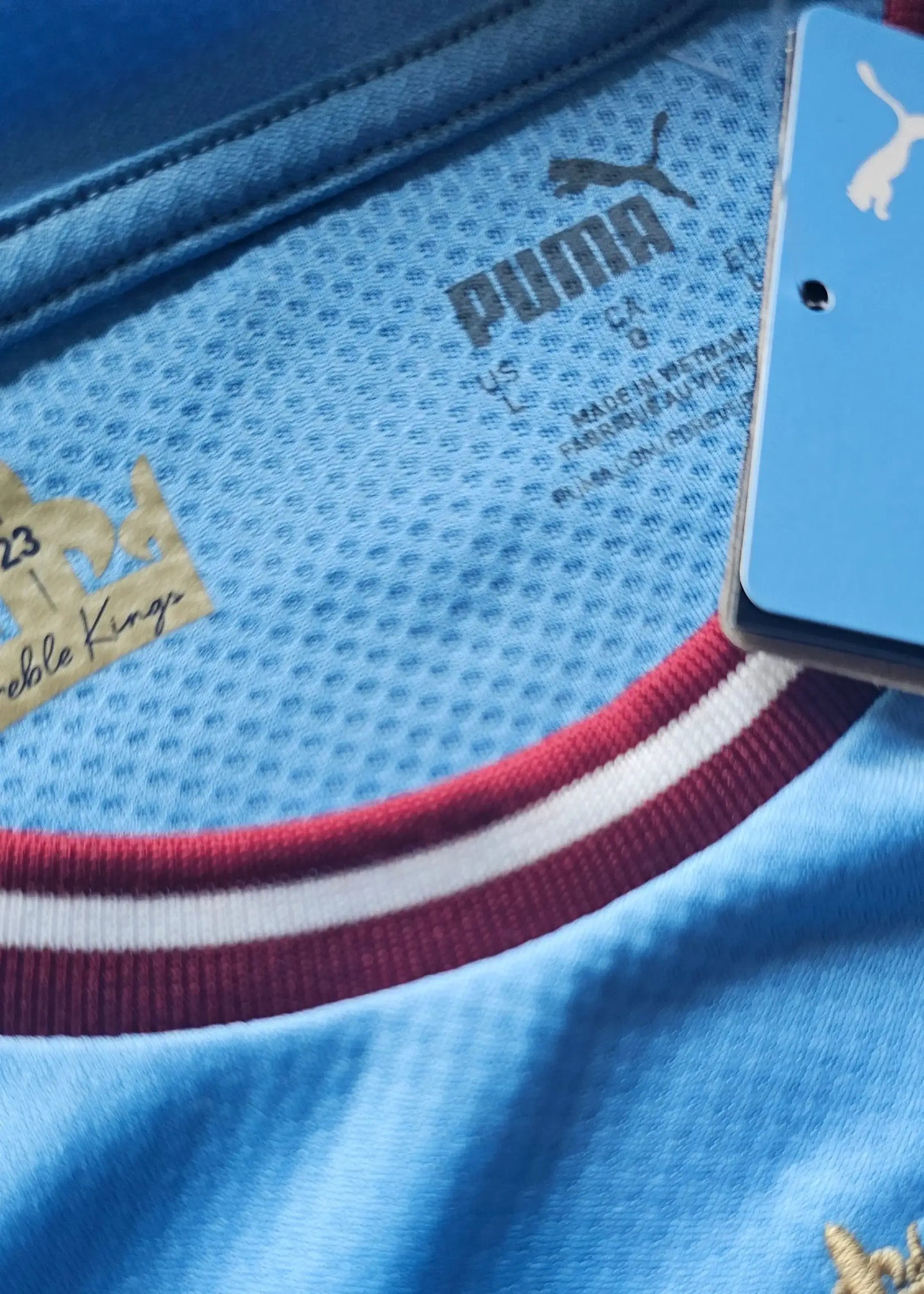 Close-up of the collar showing 'PUMA' brand and fabric details on a blue football shirt.