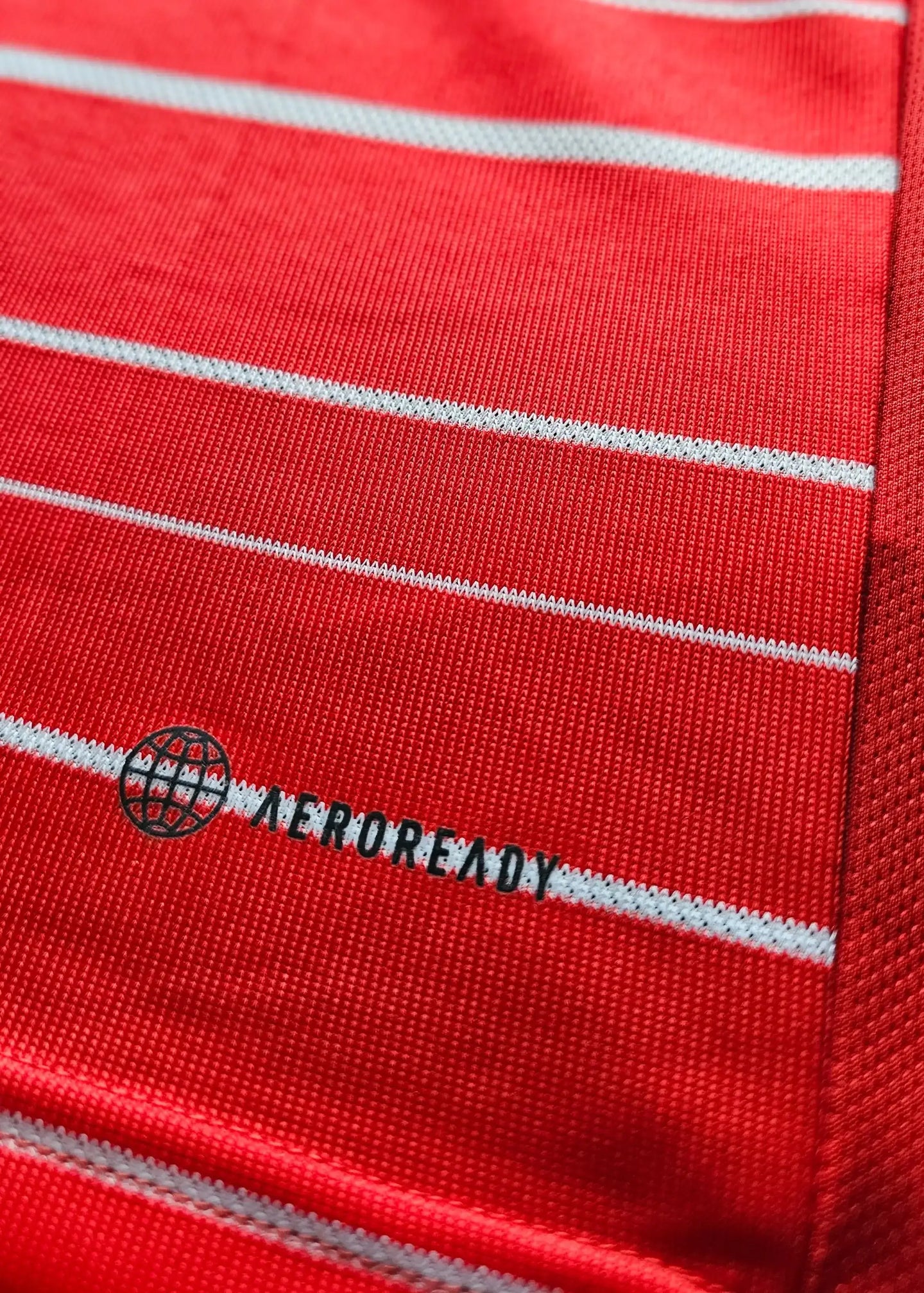 Close-up view showing the red fabric with white stripes and 'AEROREADY' text.