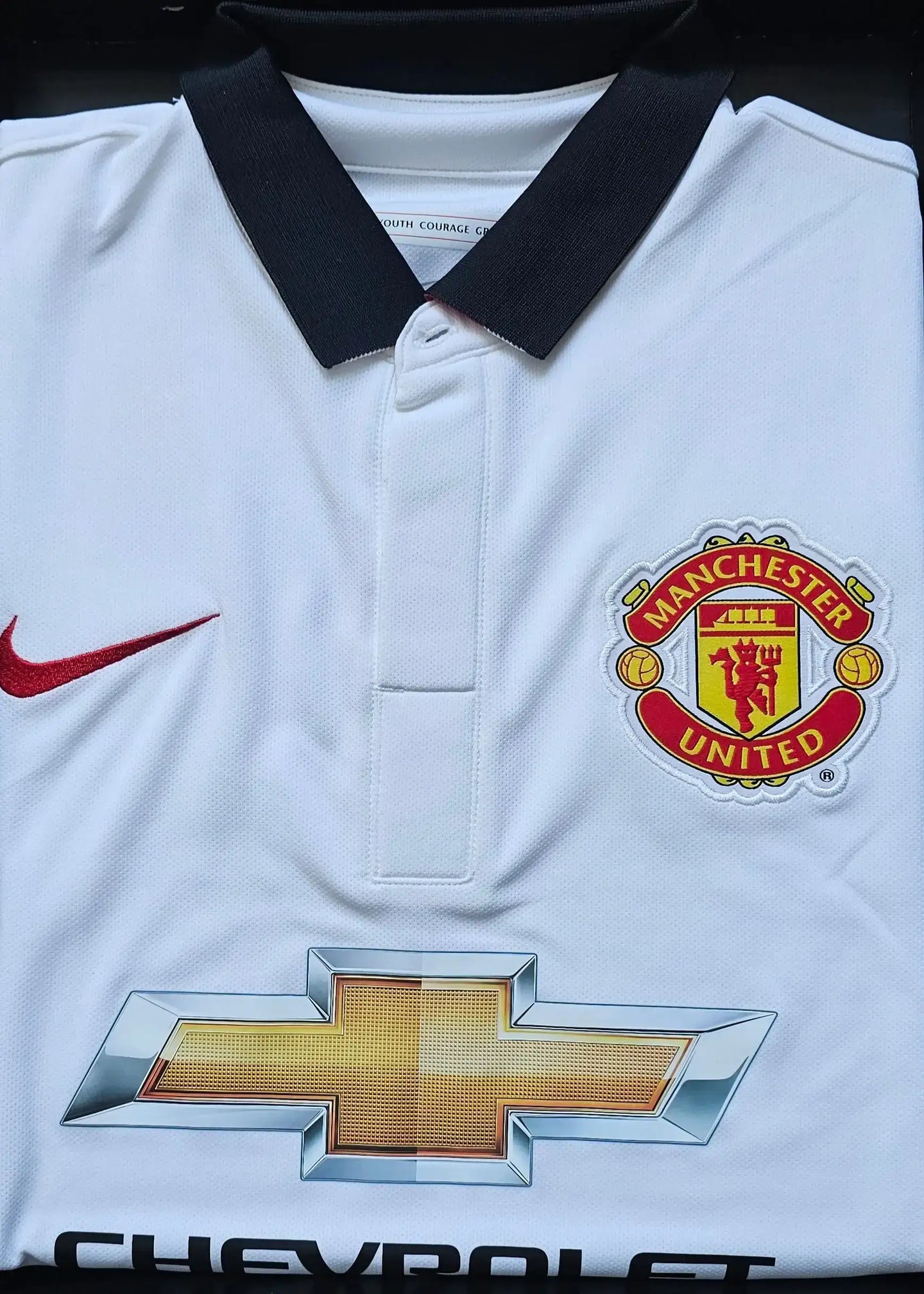 Front view featuring Manchester United crest, Chevrolet logo, and a red Nike swoosh on a white football shirt.