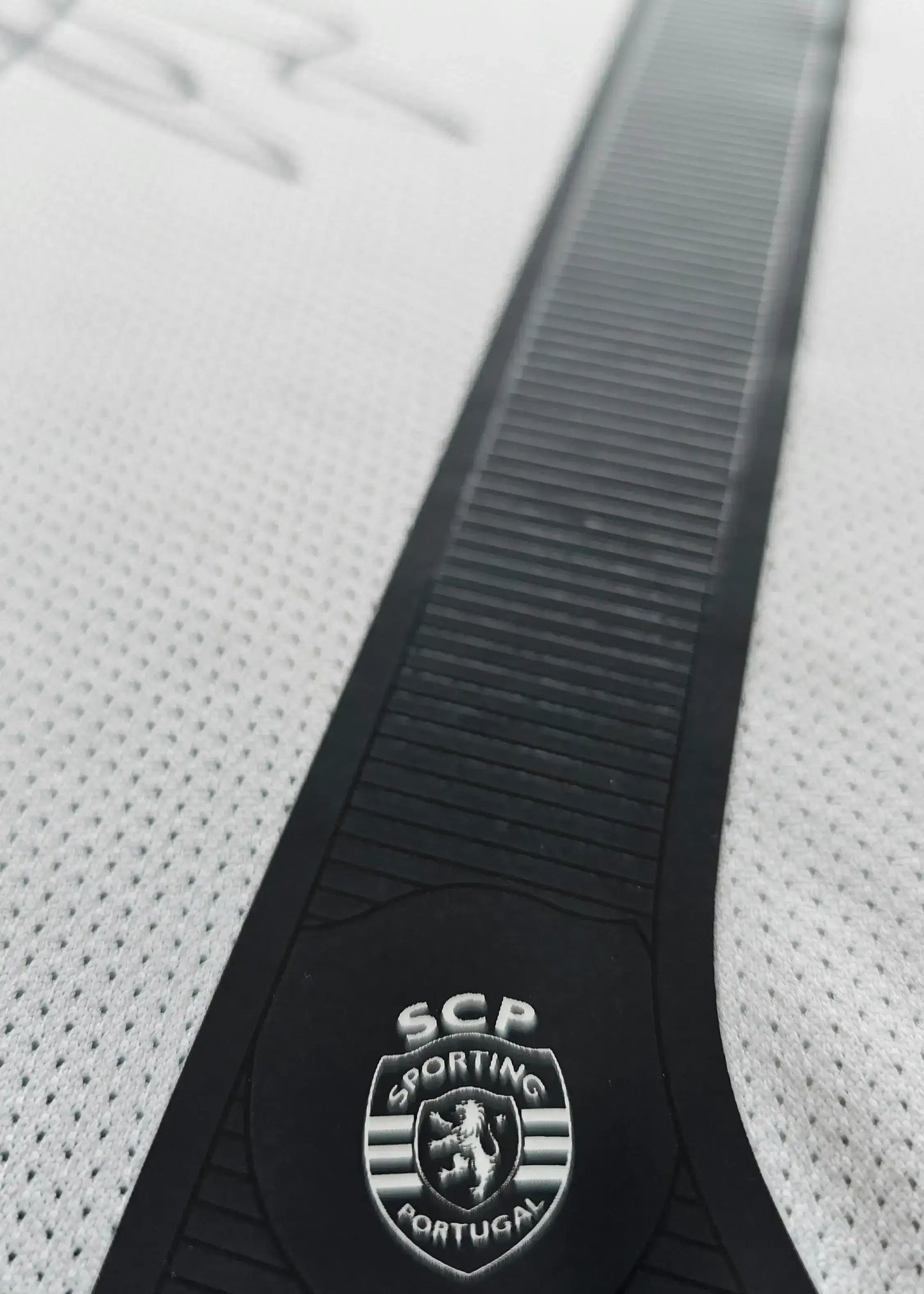 Crest detail of Sporting CP shirt featuring SCP and Sporting Portugal lettering.