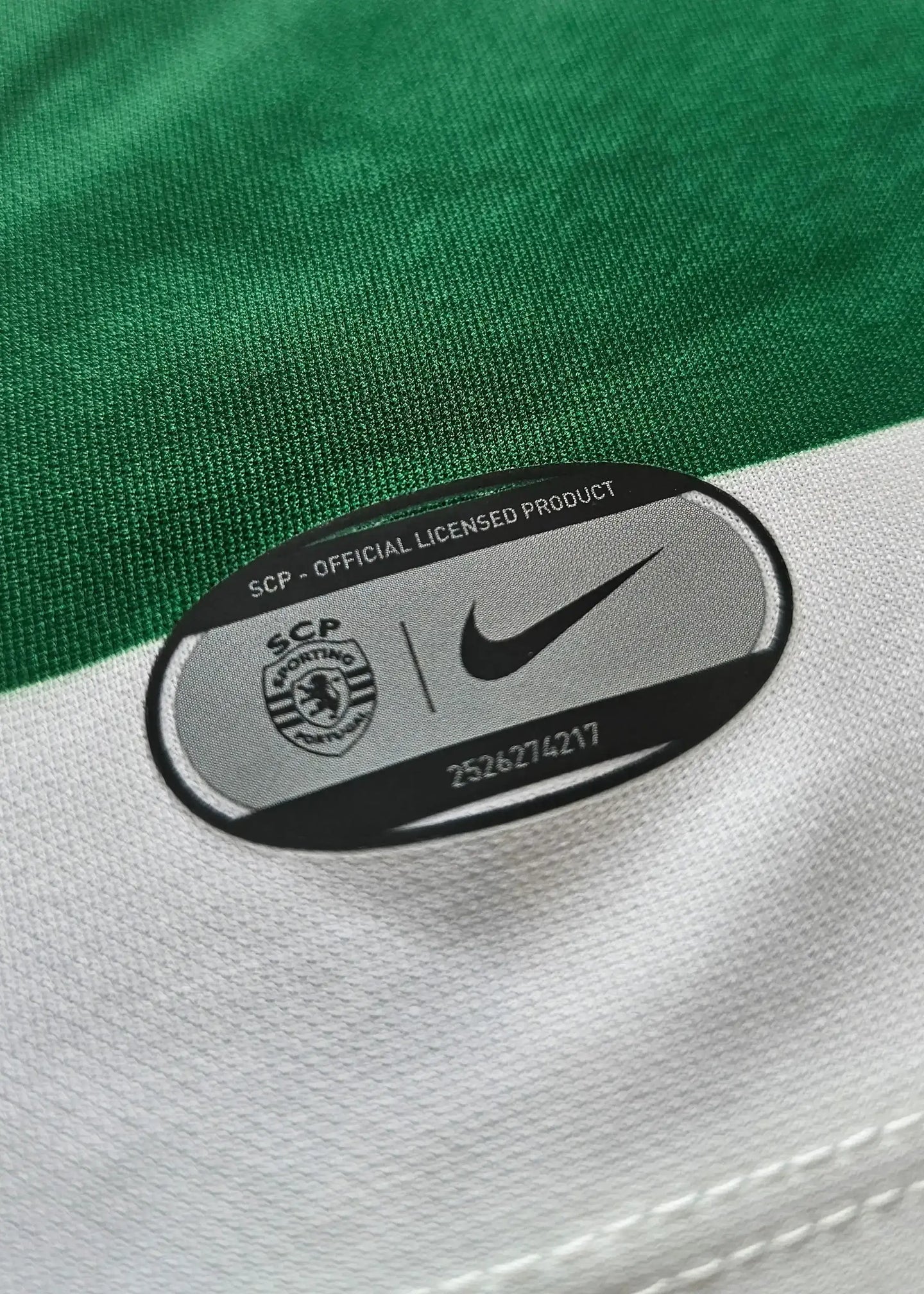 Nike logo and SCP Official Licensed Product tag on the green and white Sporting CP shirt.