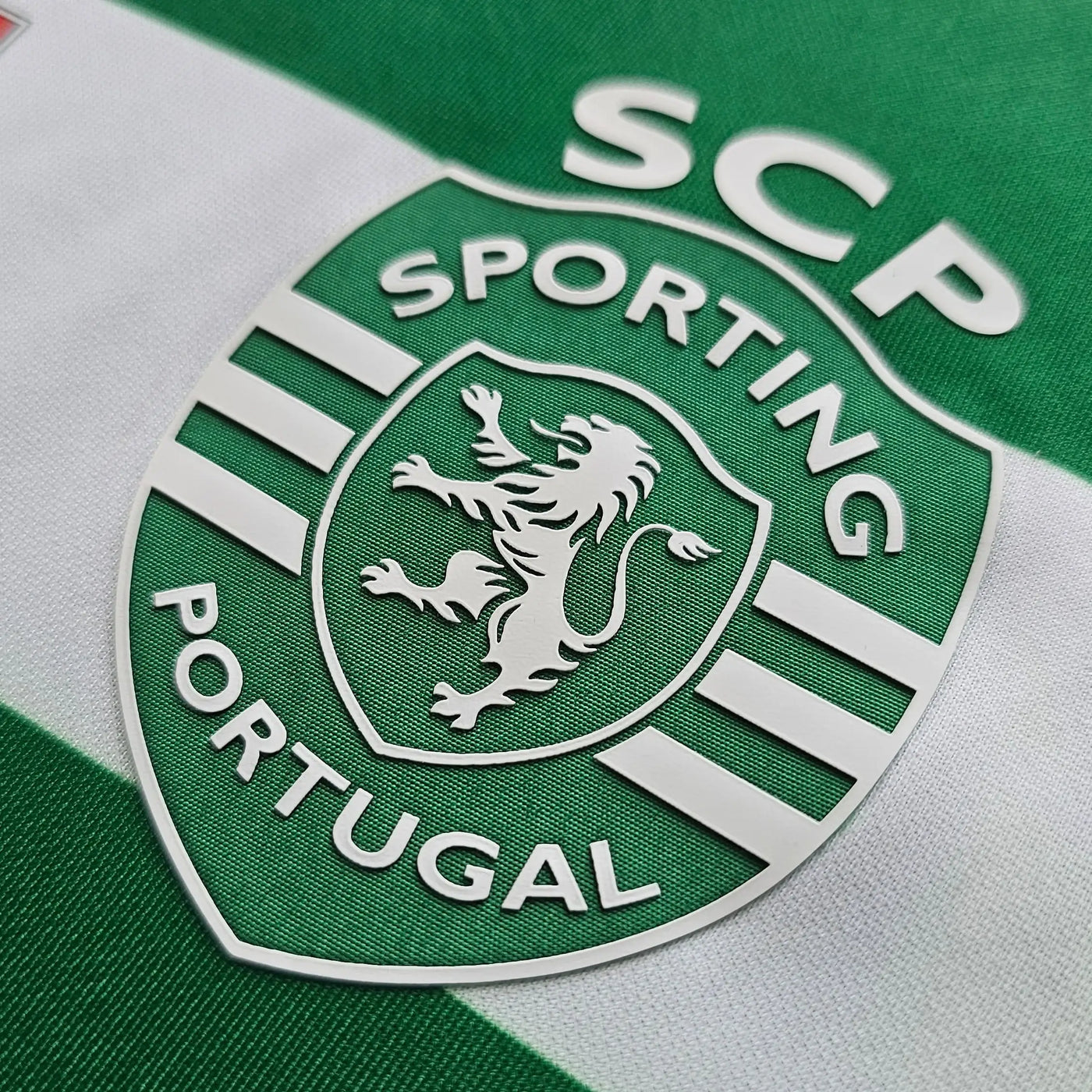 Close-up of Sporting CP logo on a green and white striped background