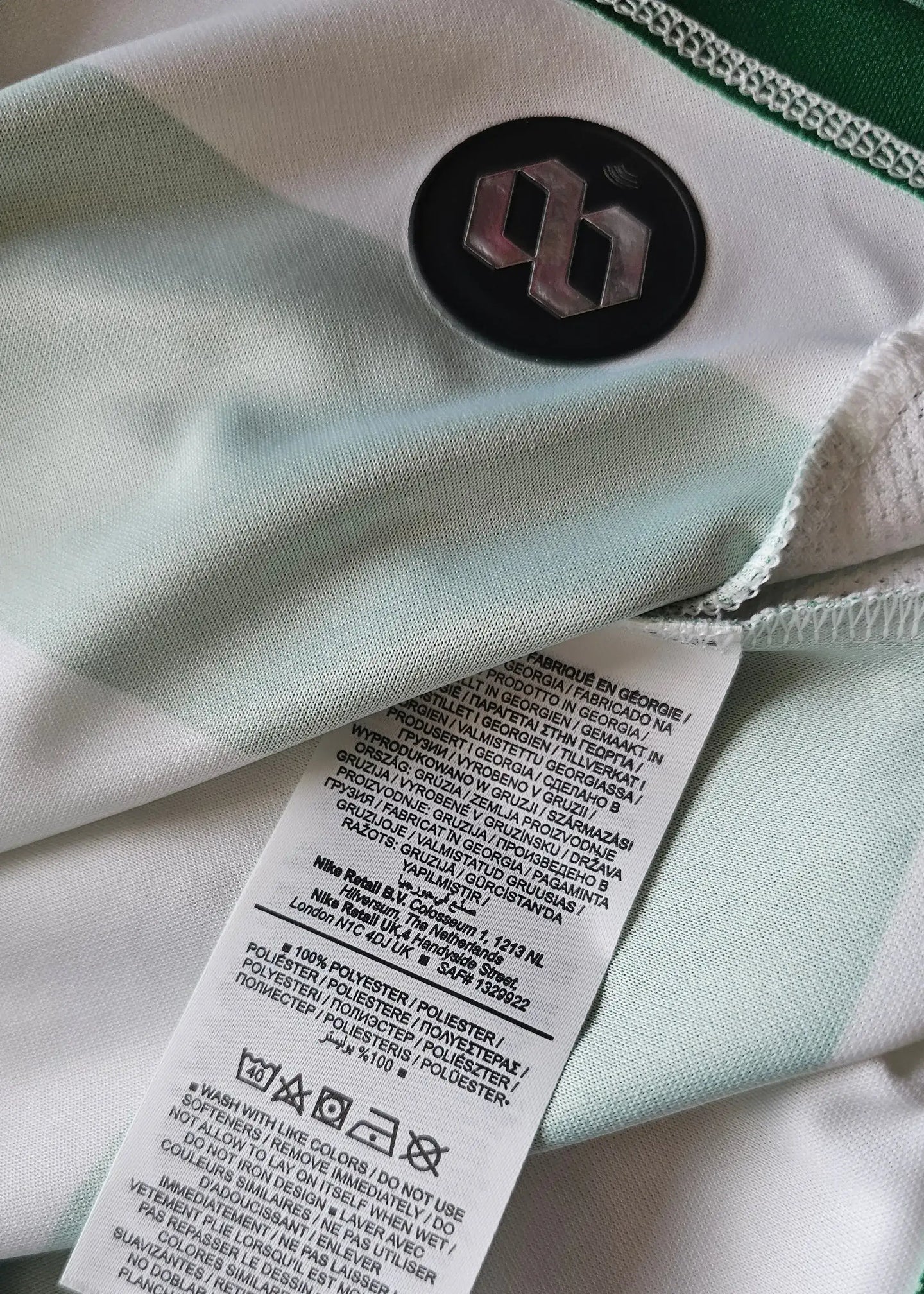 White and green striped fabric with black logo and care label details.