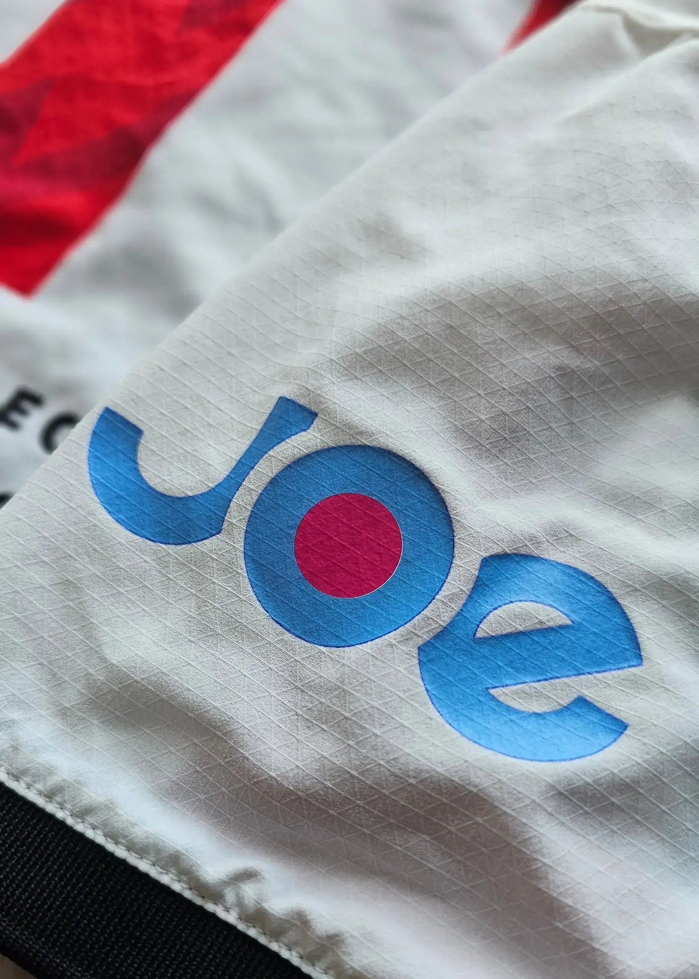 Close-up of the white sleeve featuring the blue and pink logo of Joe.