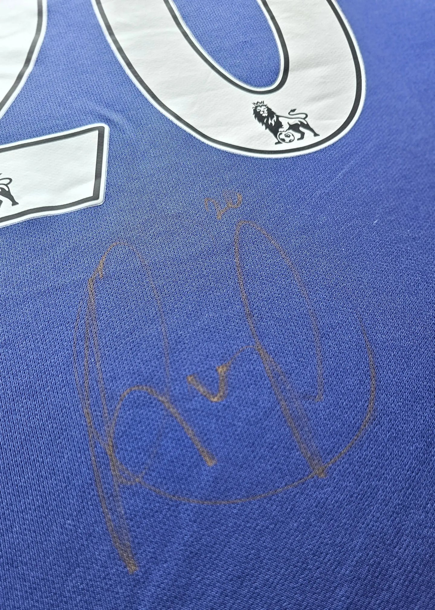 No. 20 on blue fabric with Robin van Persie signature visible below, Manchester United crest at the top.