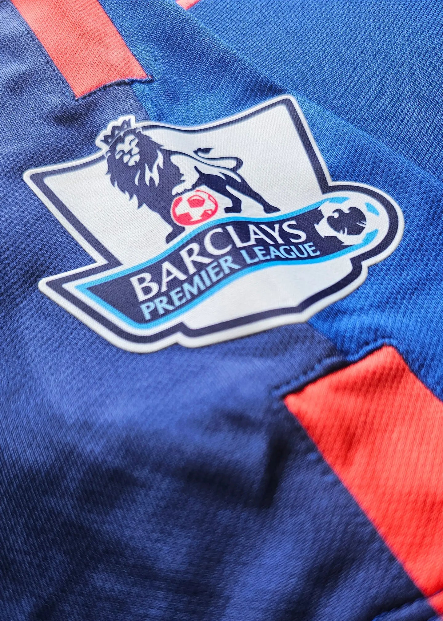 Close-up of the lion crest with Barclays Premier League logo on a blue football shirt.