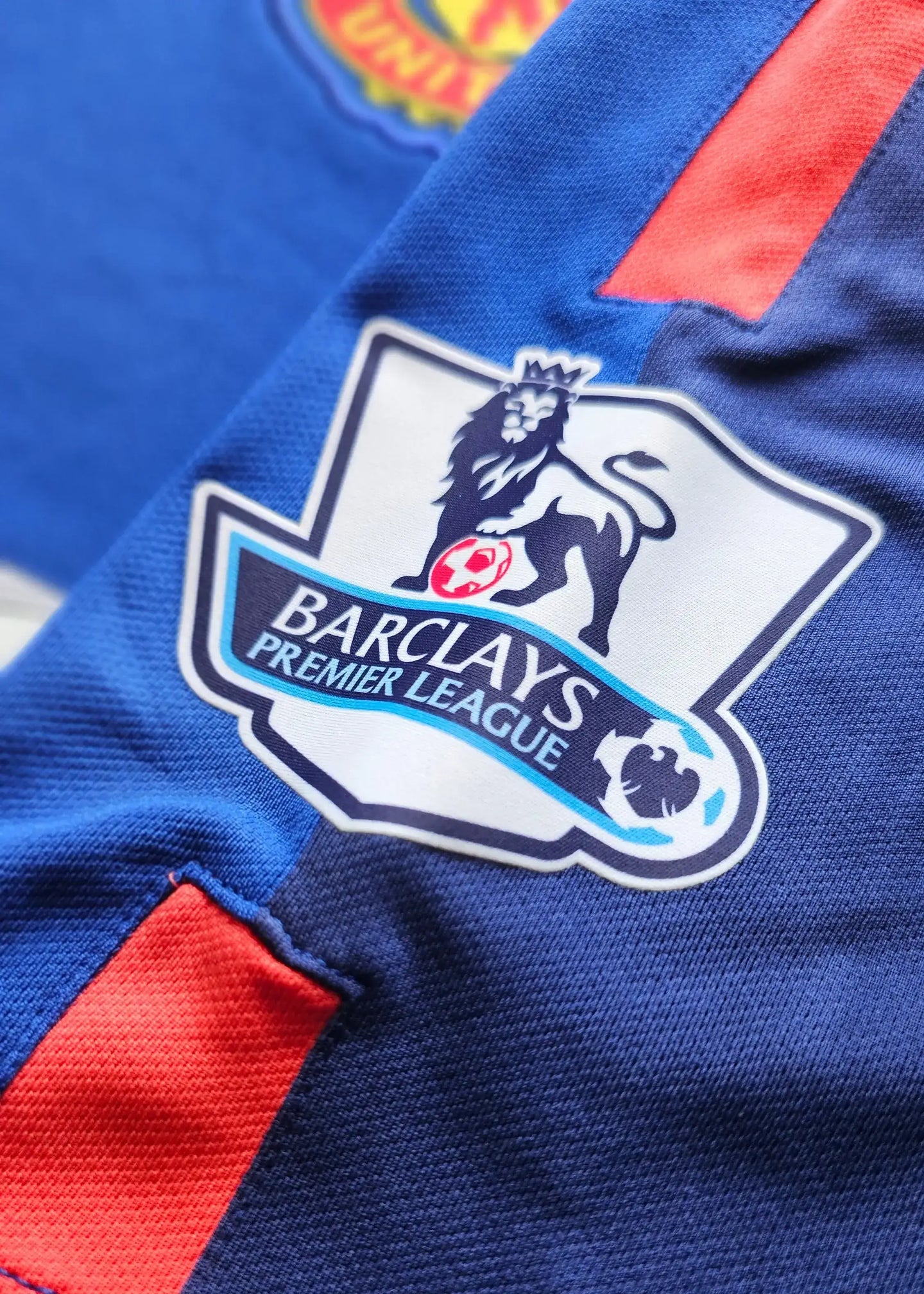 Close-up of the crest featuring the Barclays Premier League logo and a lion on blue fabric.