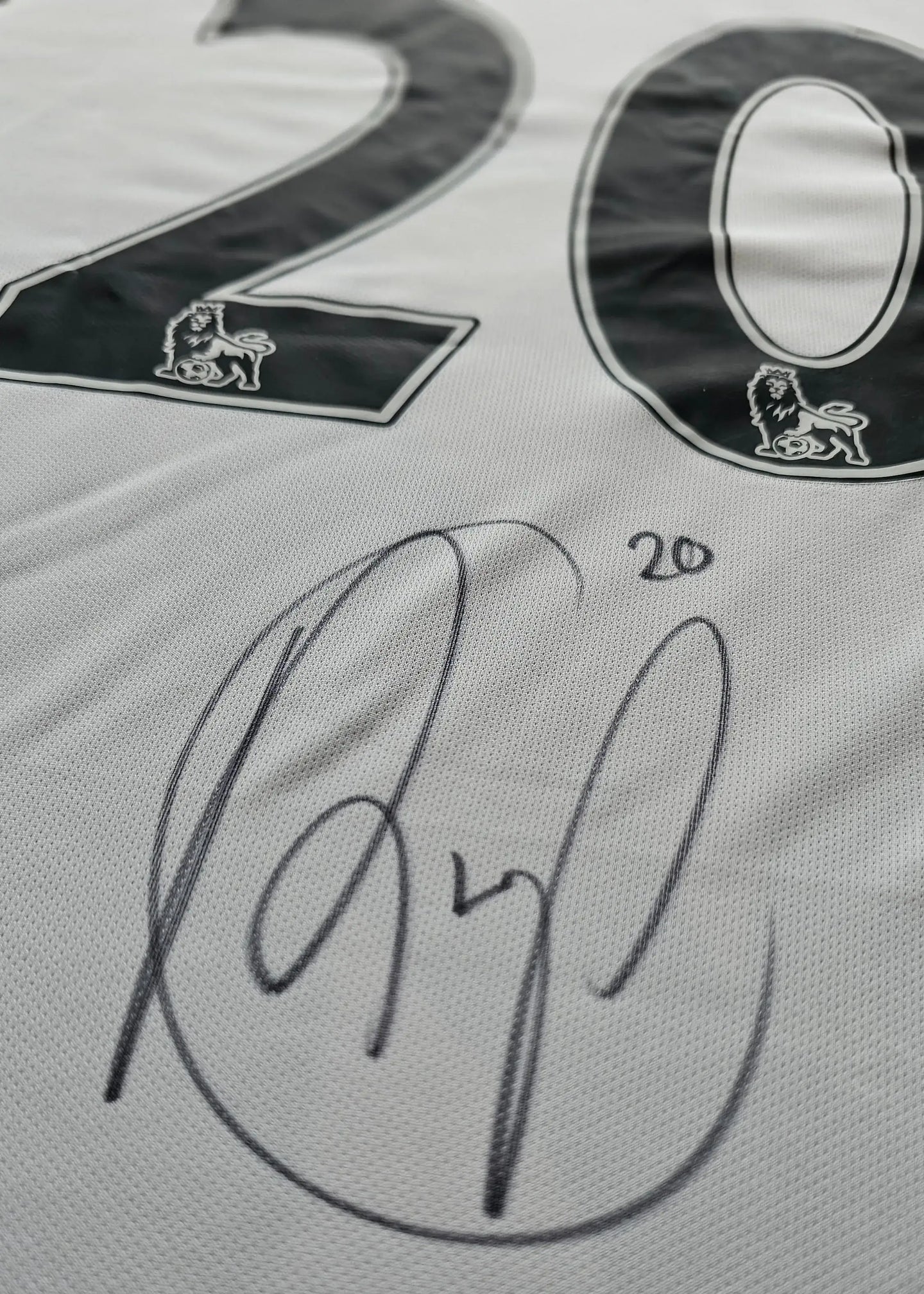 White Manchester United shirt with No. 20 and Robin van Persie's signature below the number.