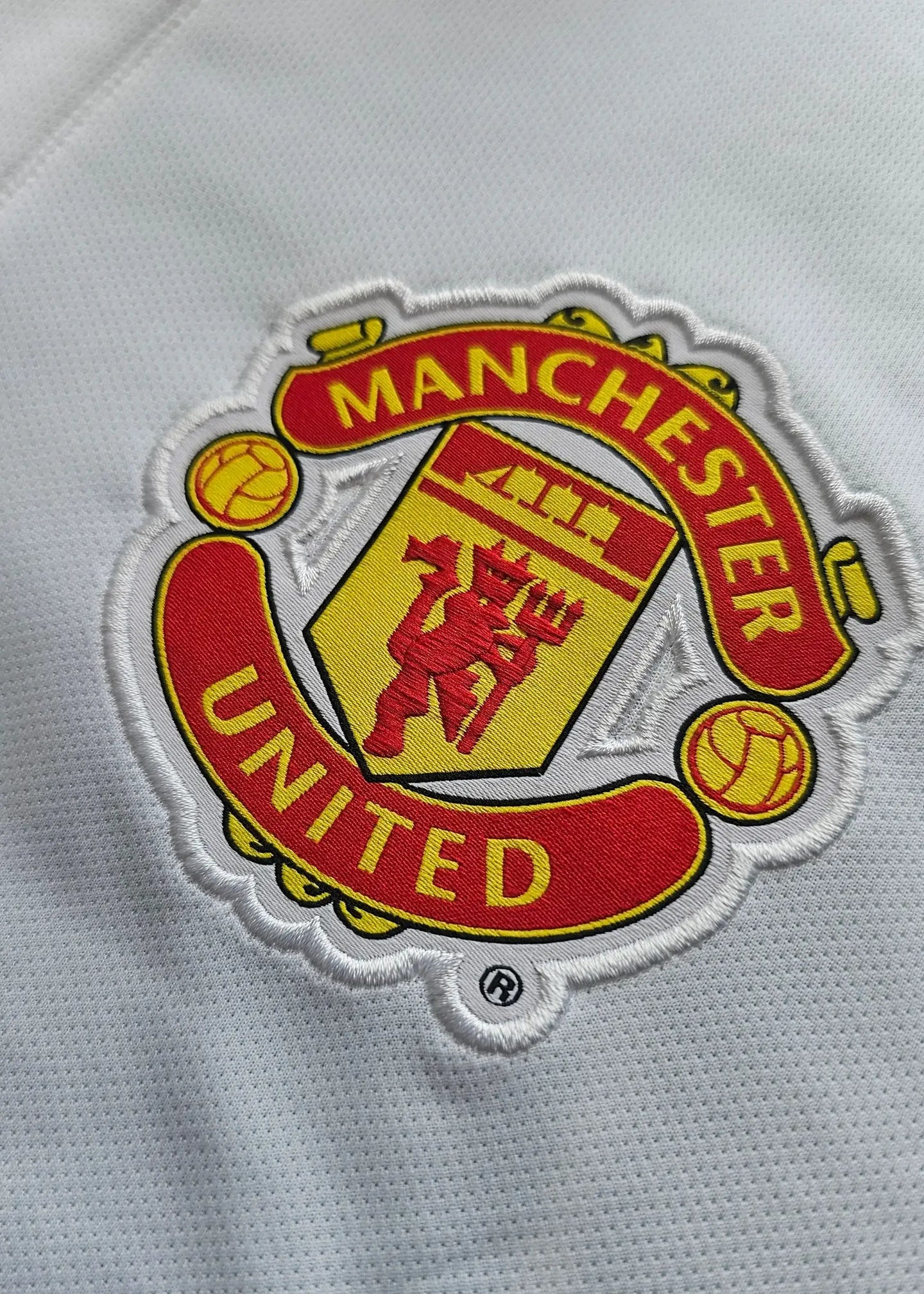 Close-up of Manchester United crest featuring red, yellow, and white detailing.