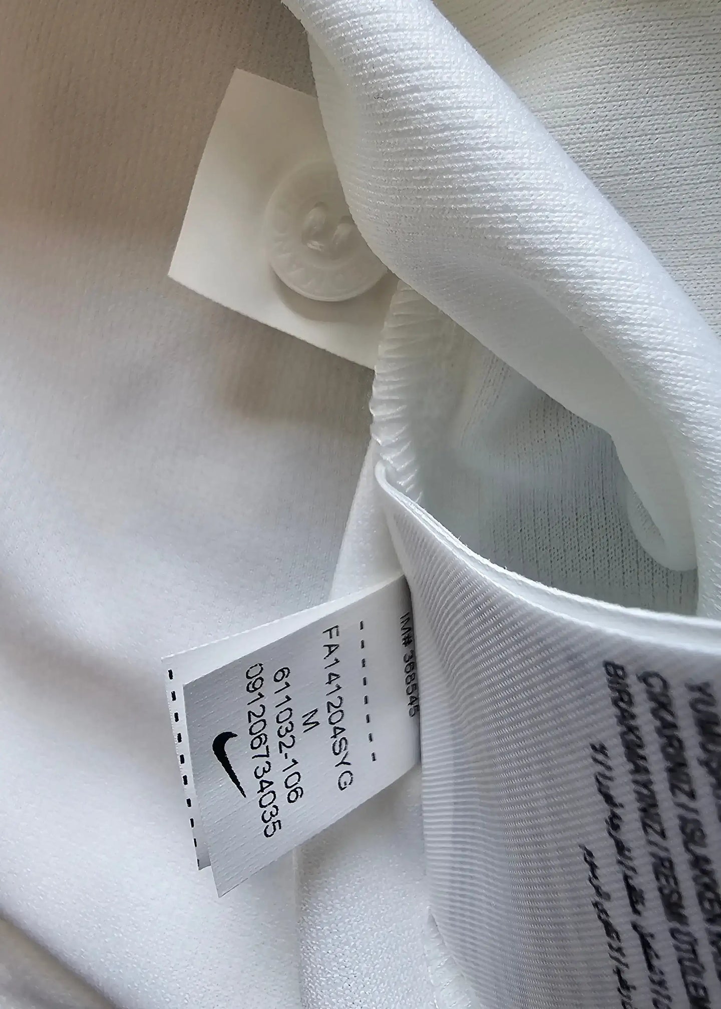 Care label showing Nike logo, size M, and code FA4141204SY on white fabric.