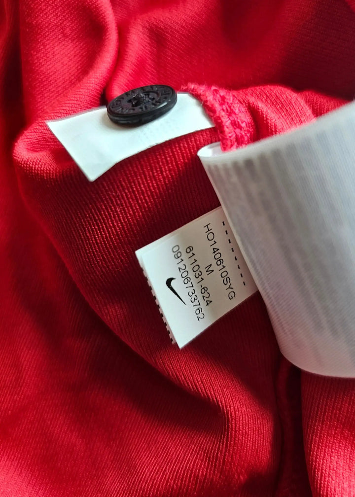 Red shirt with Nike tag, size M, and care label visible on the collar area.