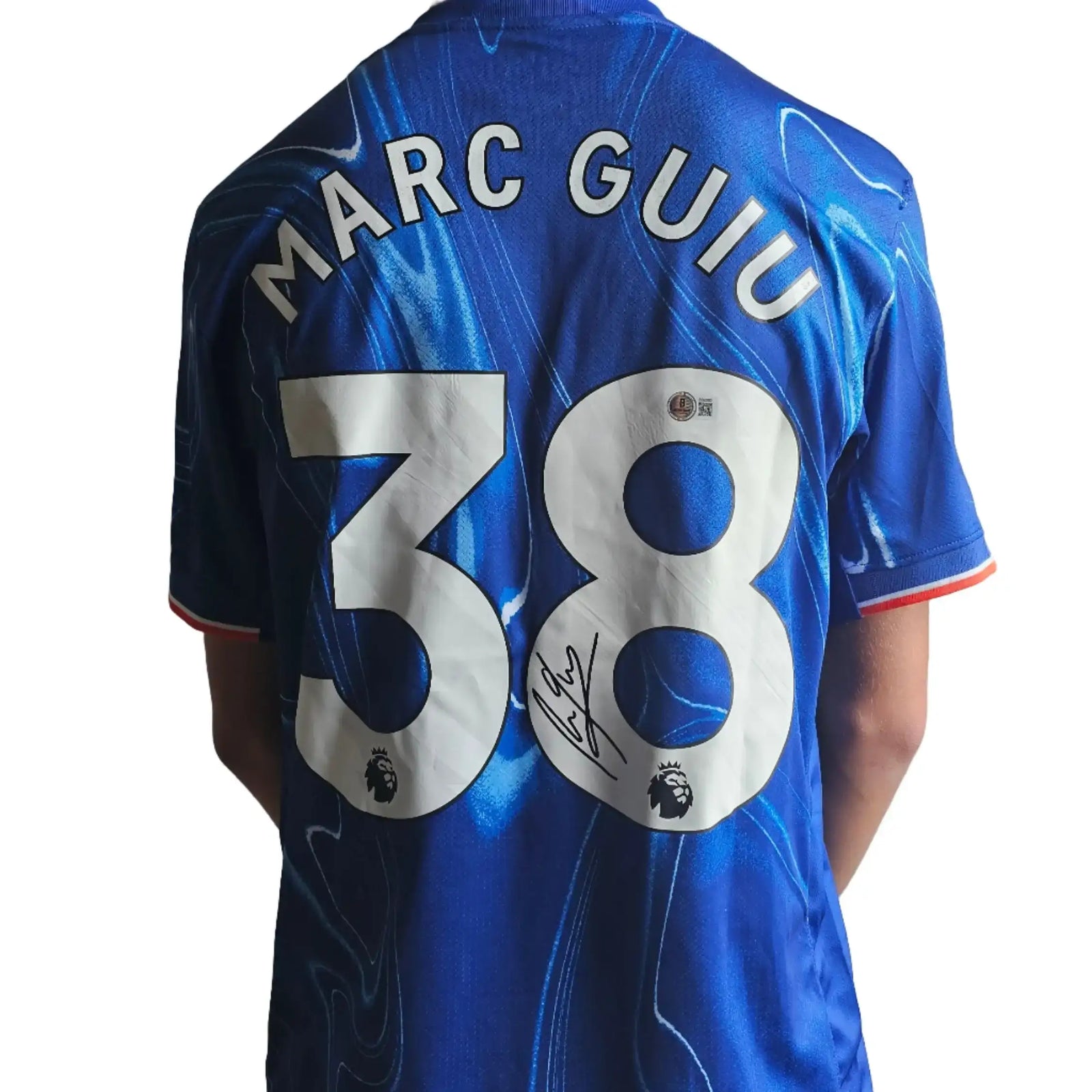 Back view featuring Marc Guiu, No. 38, and a visible signature on a blue Chelsea football shirt.